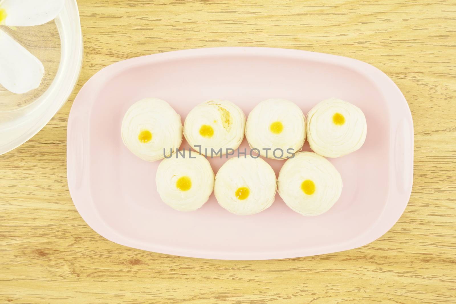 Chinese pastry place on a pink tray with wood background.