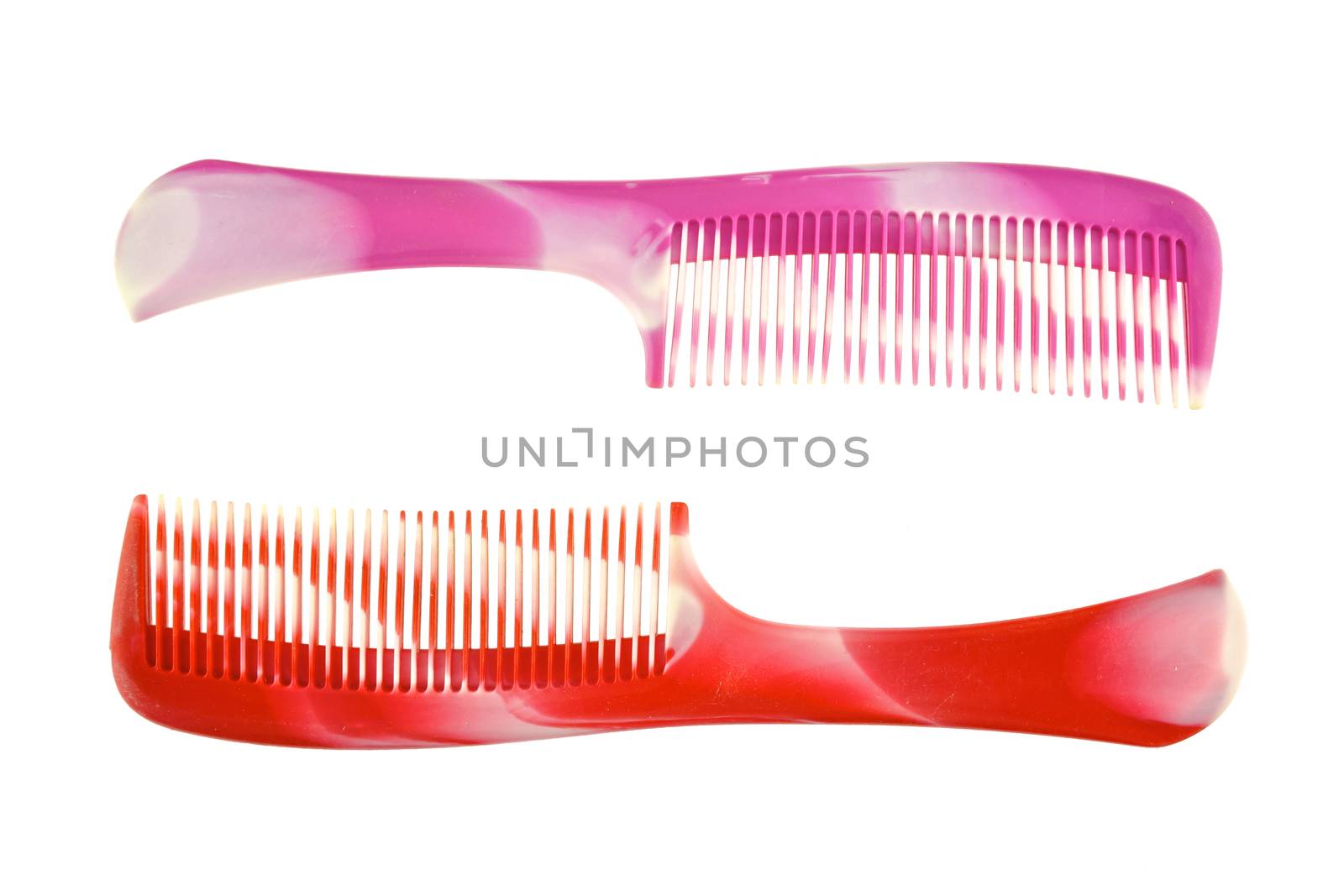 Red and pink comb placed on opposite side isolated with white background.