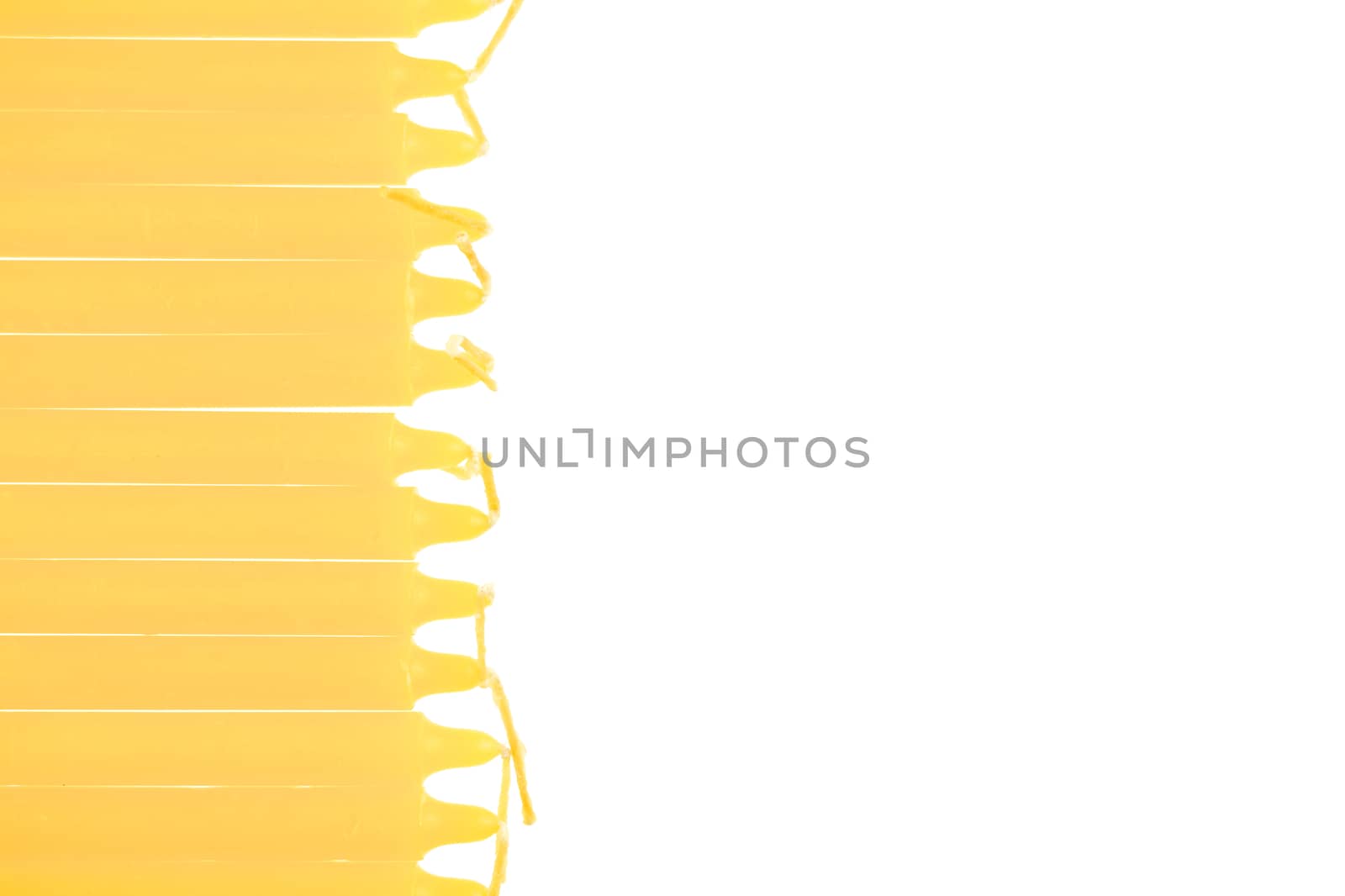 Yellow candle put as raft on left isolated with white background.