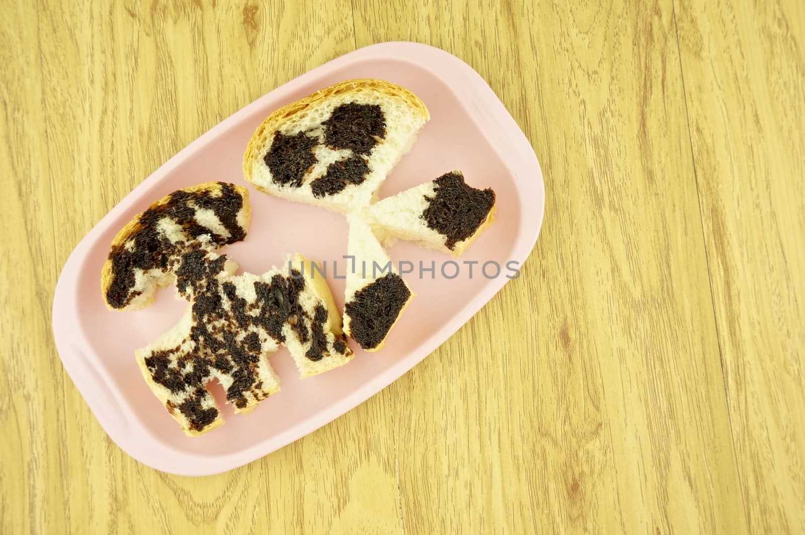 Bread pour with chocolate as rocket and alien place on pink tray on wood background.