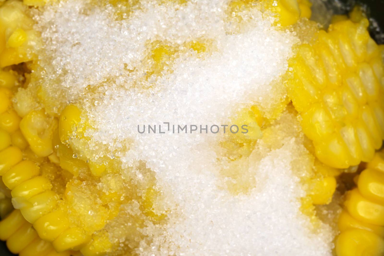 Closeup shear corn with sugar and salt in black bowl.