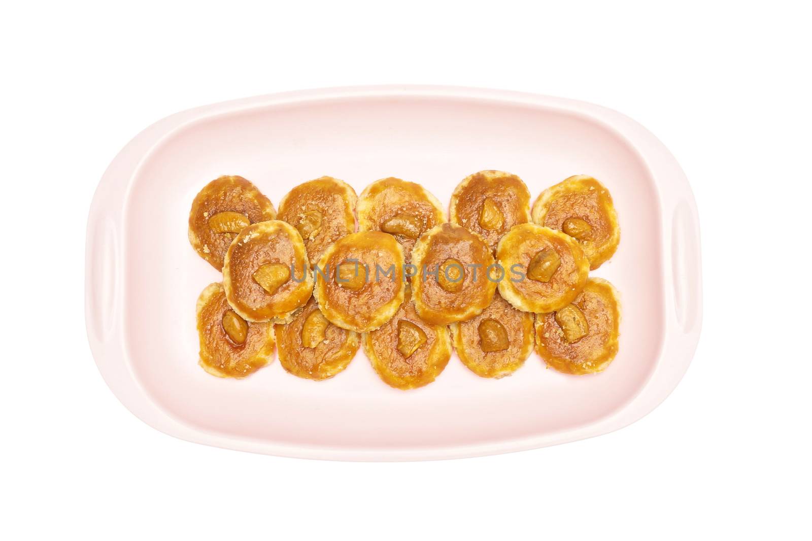 Cookie and cashew nut put on pink tray isolated with white background.