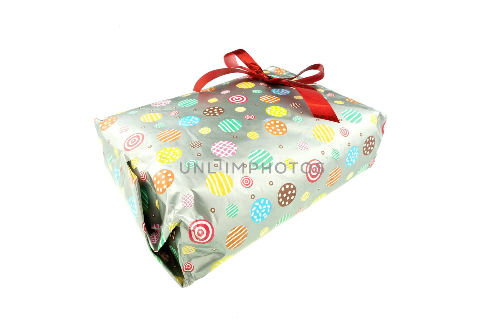 Gift wrap with paper colorful circle pattern and red ribbon isolated on white background.