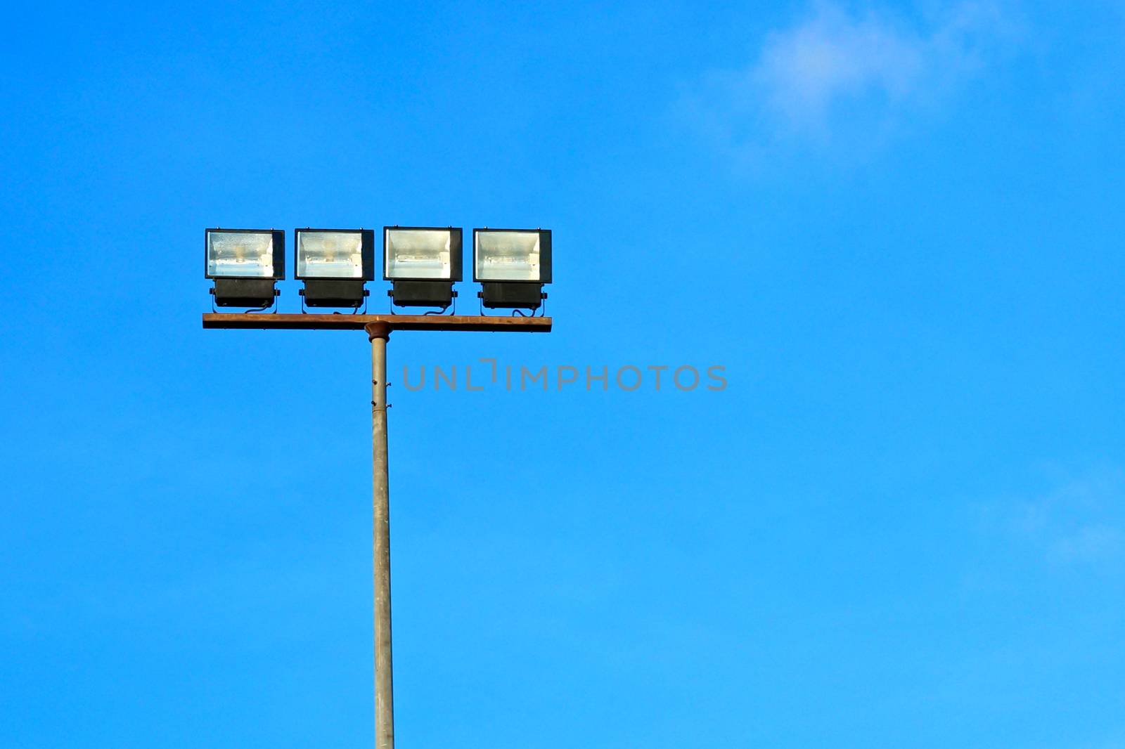 Spotlight halogen for irradiate to the football field with blue sky background.