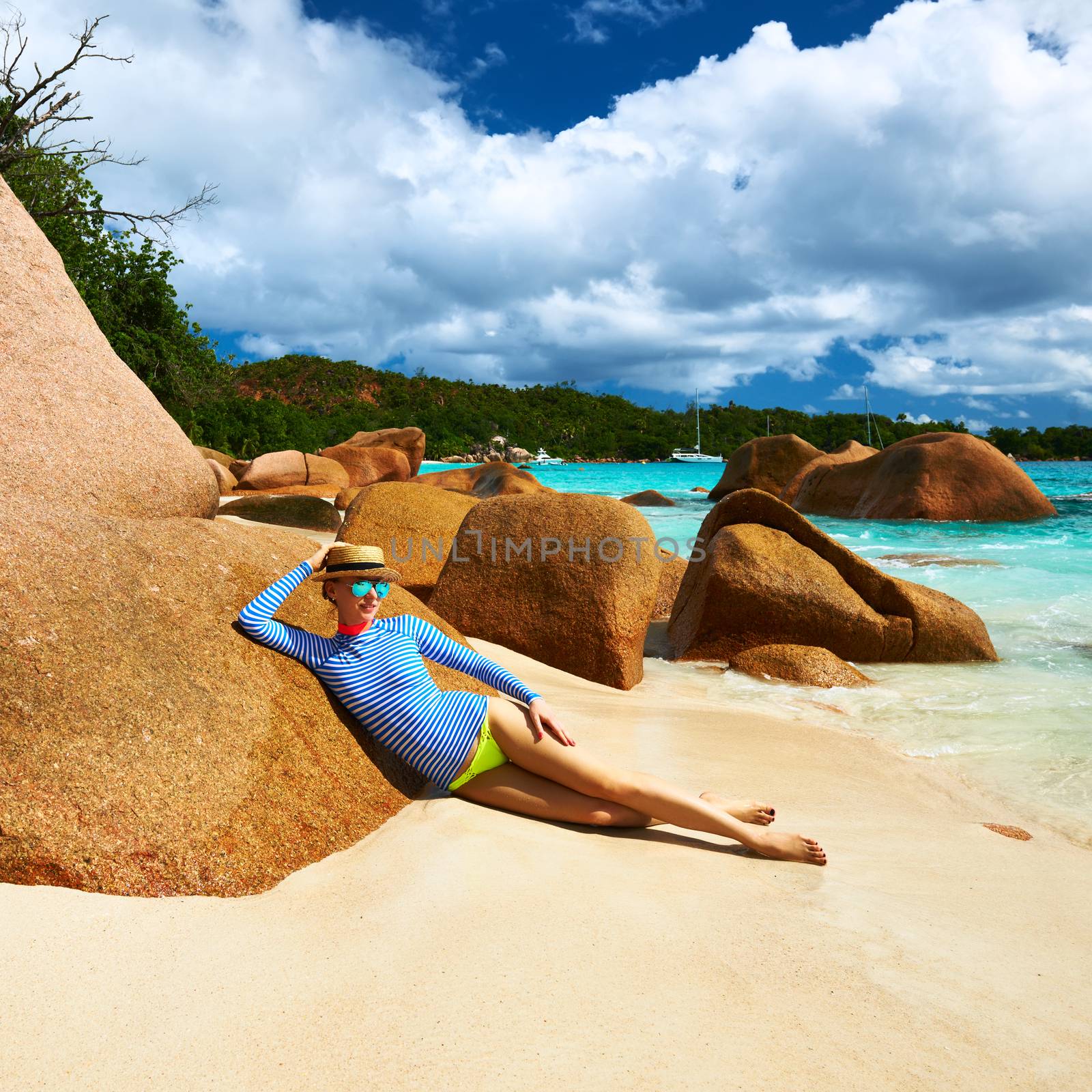 Woman at beautiful beach wearing rash guard. Seychelles, Praslin, Anse Lazio
