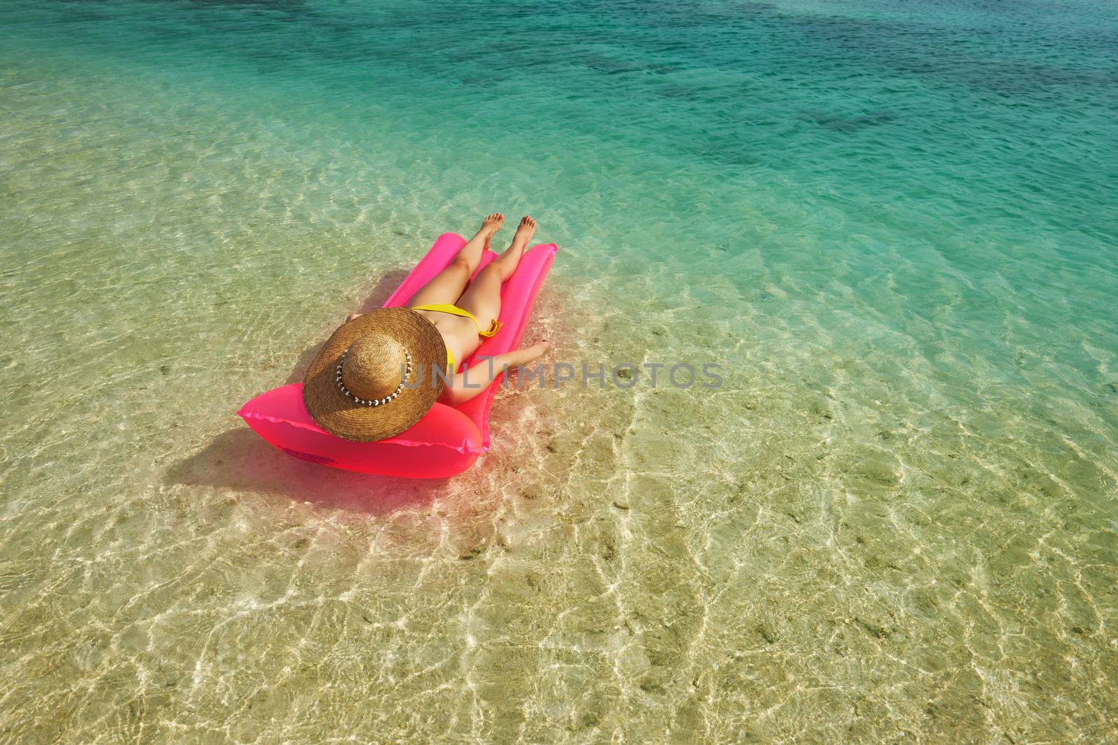 Woman relaxing on inflatable mattress near the beach