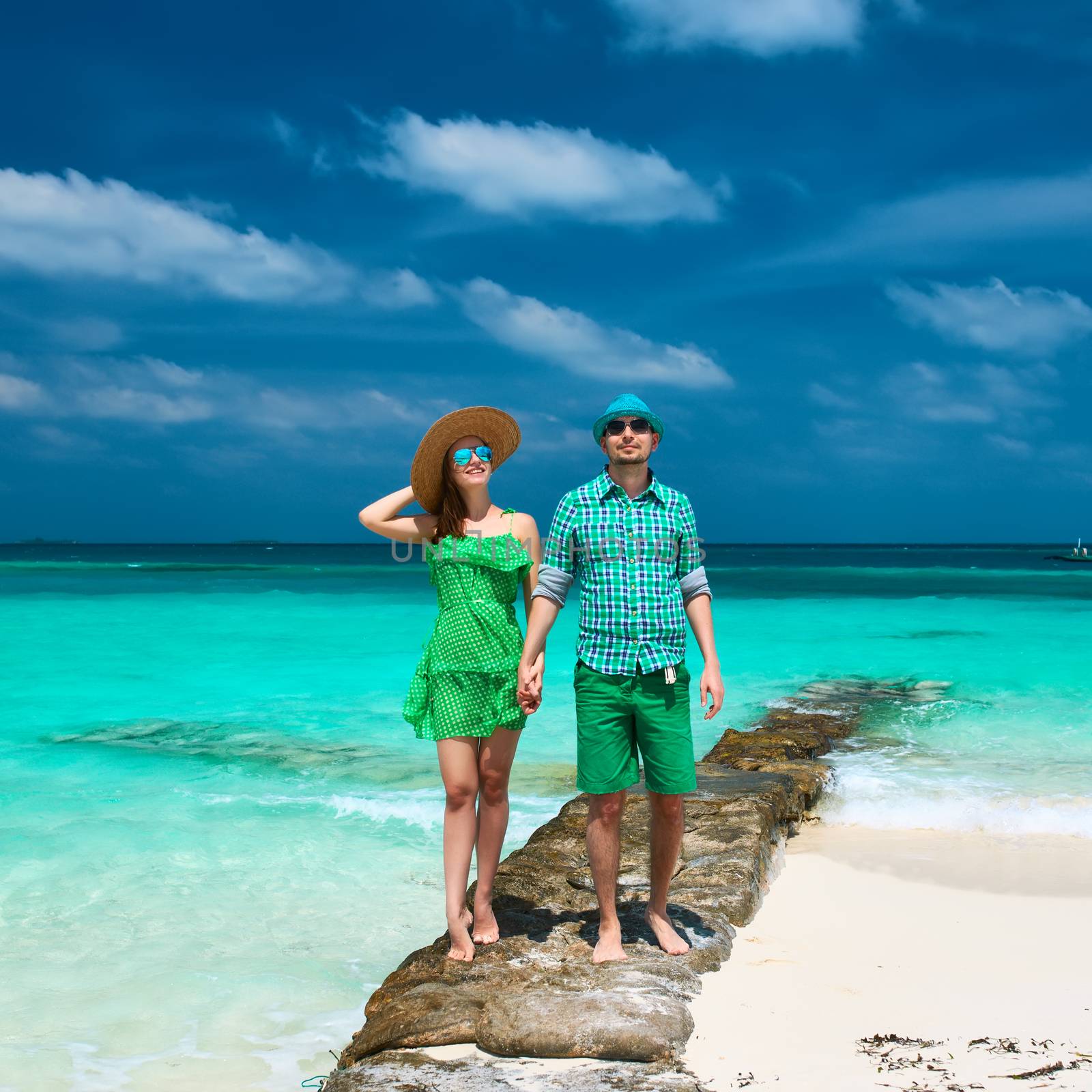 Couple in green on a tropical beach at Maldives