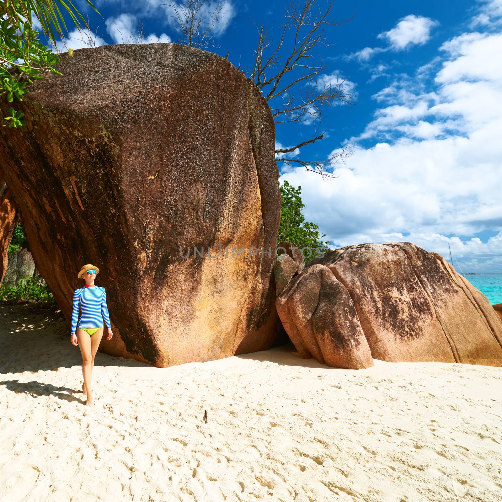 Woman at beautiful beach wearing rash guard. Seychelles, Praslin, Anse Lazio