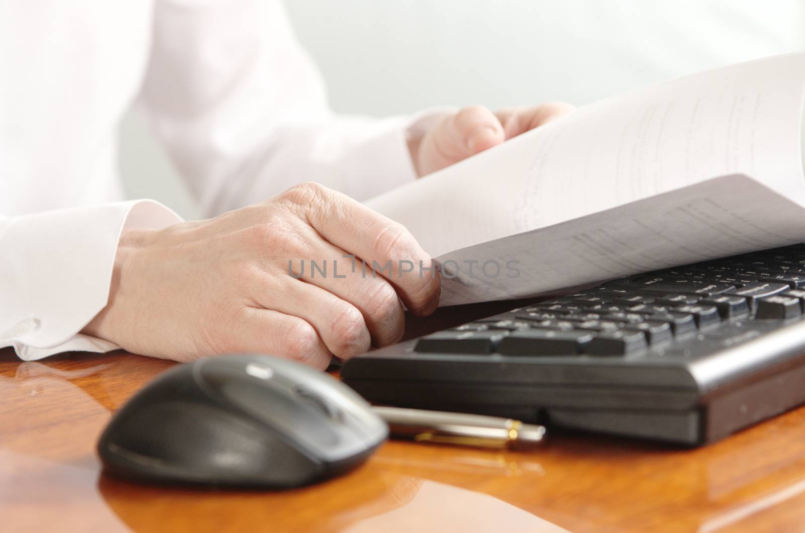 Hands with a document on a computer keyboard