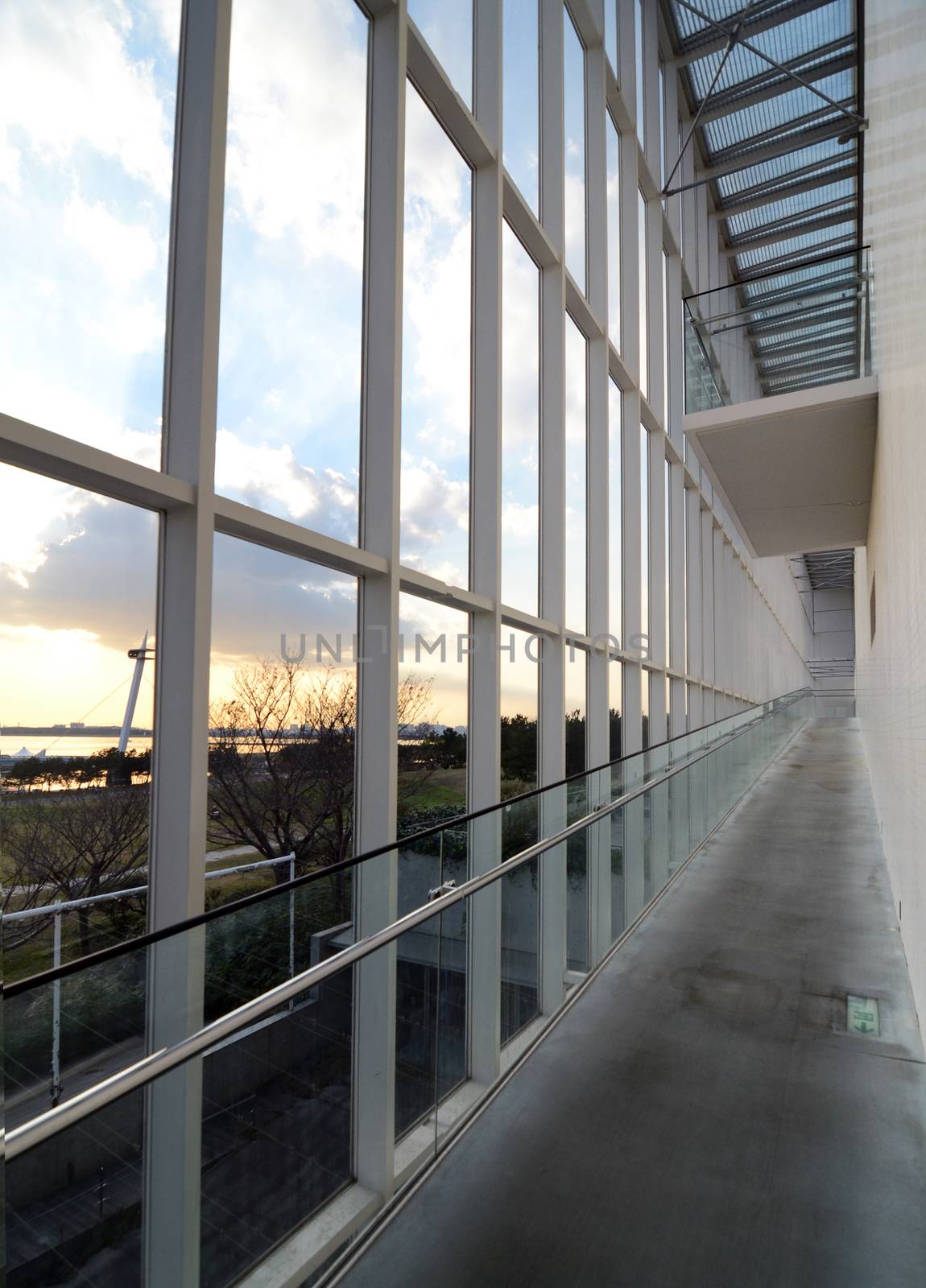 Long corridor in the modern building, sunset in the background