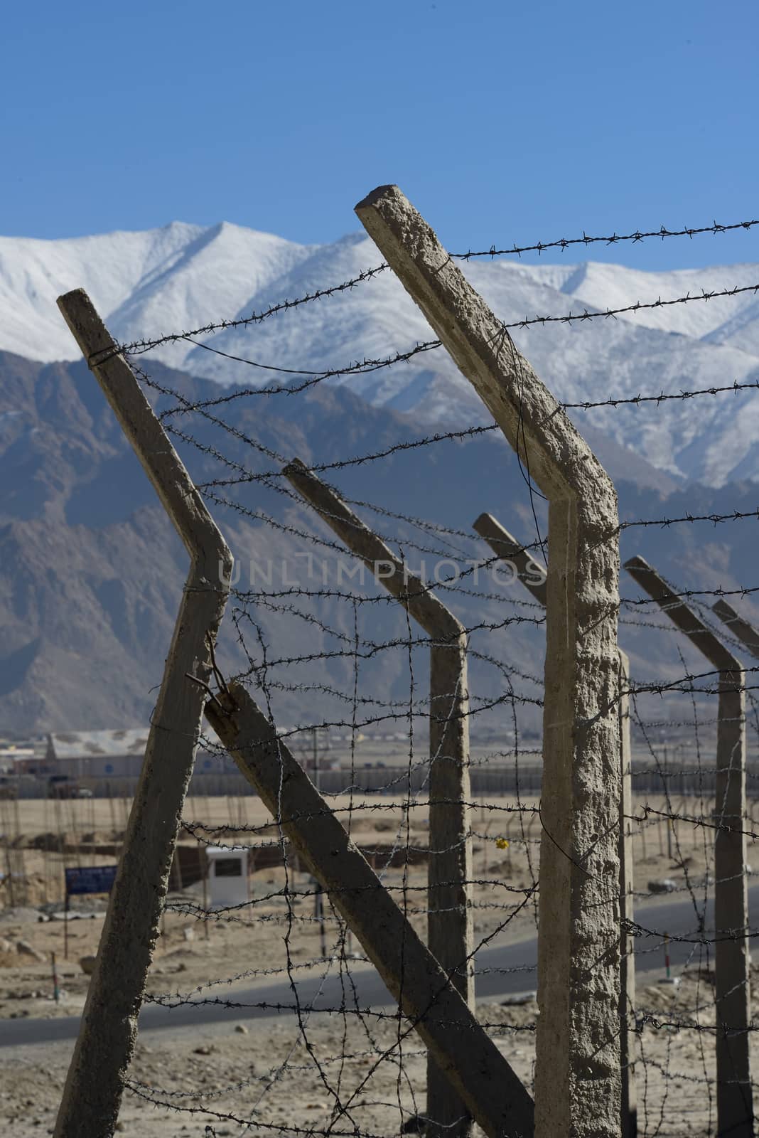 Barbed wire fence in winter with snow mountain background