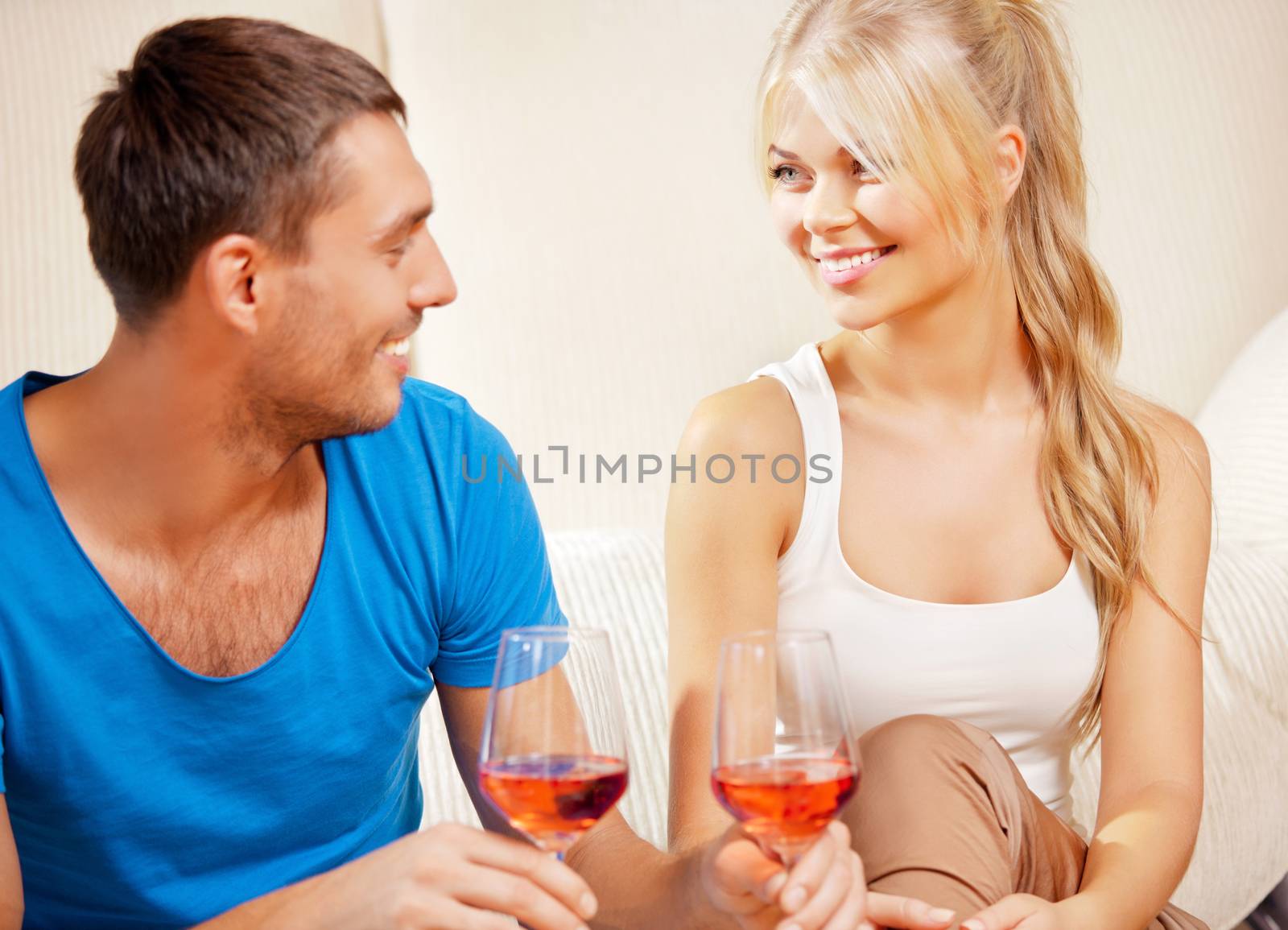 picture of happy romantic couple drinking wine (focus on woman)