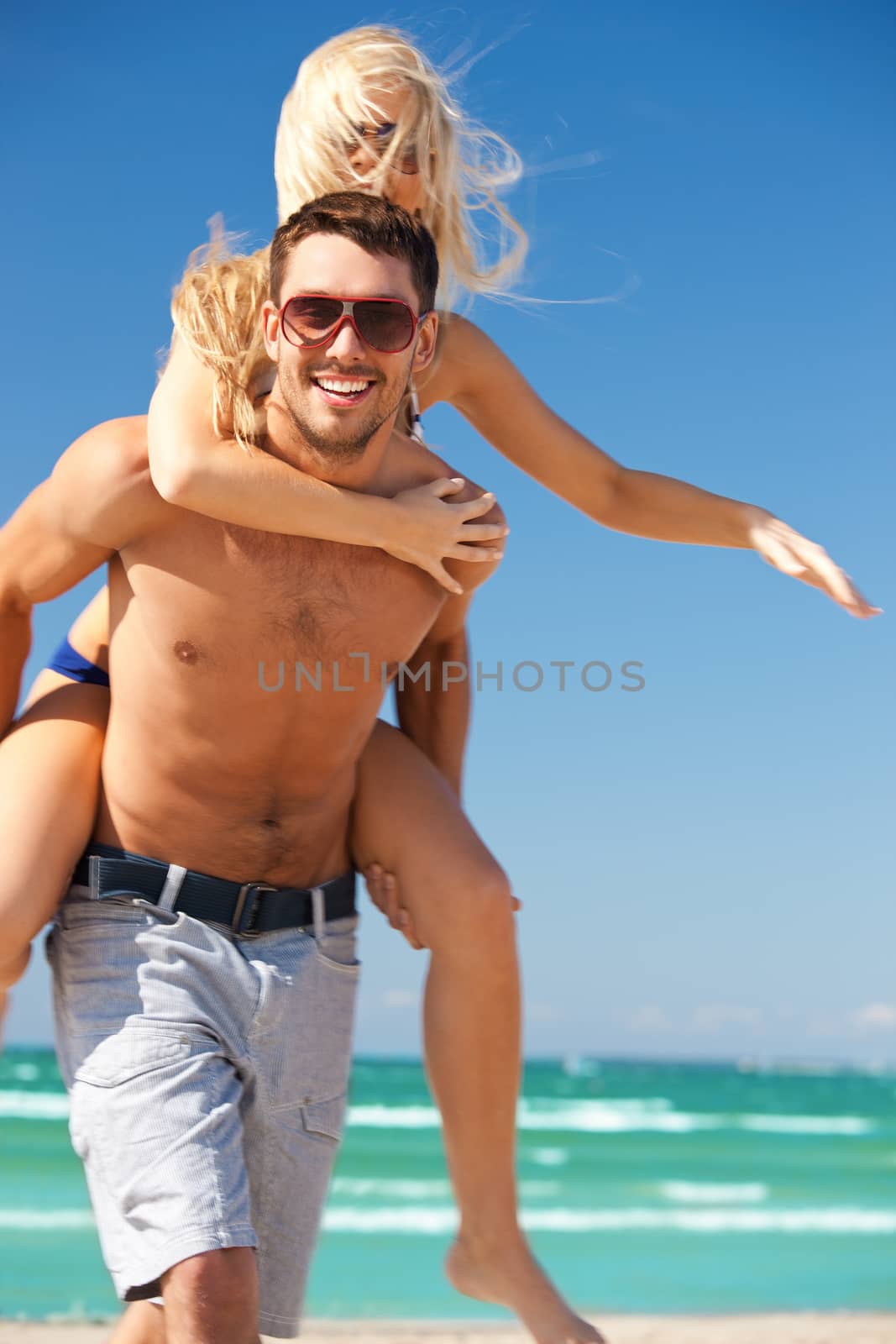 happy couple in sunglasses on the beach by dolgachov