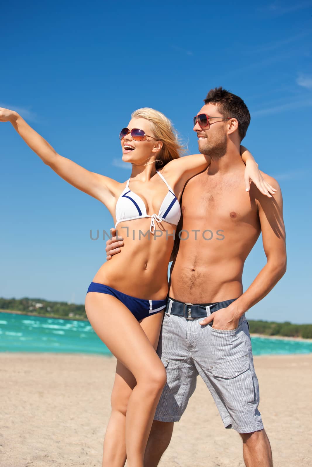 happy couple in sunglasses on the beach by dolgachov