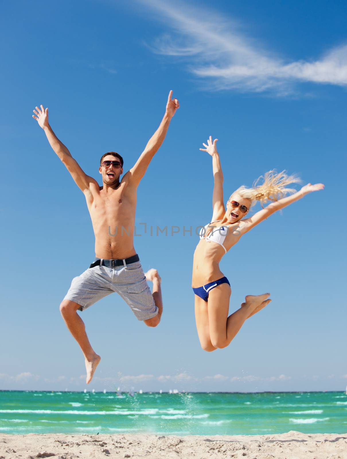 picture of happy couple jumping on the beach (focus on man)