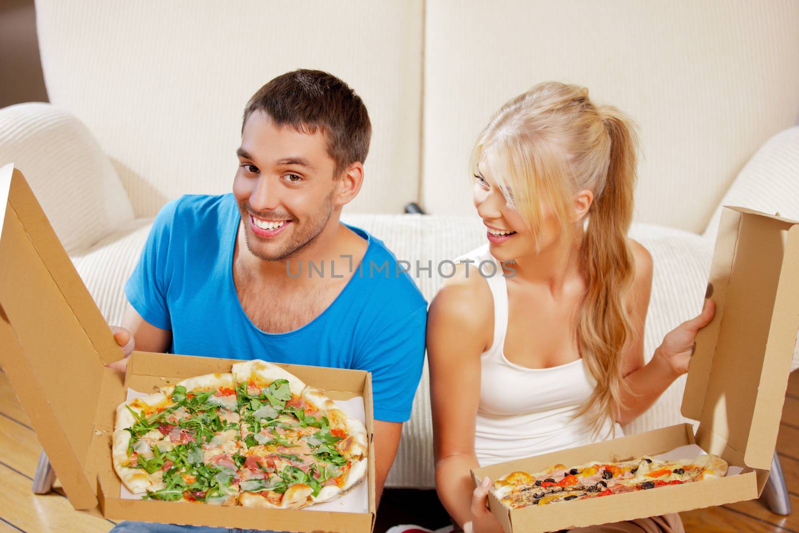 picture of happy romantic couple eating pizza at home (focus on man)
