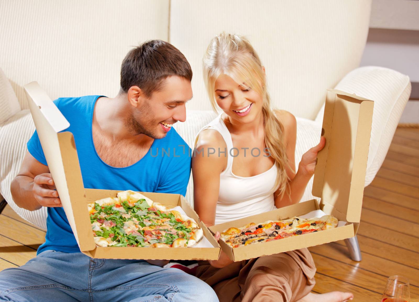 picture of happy romantic couple eating pizza at home (focus on man)