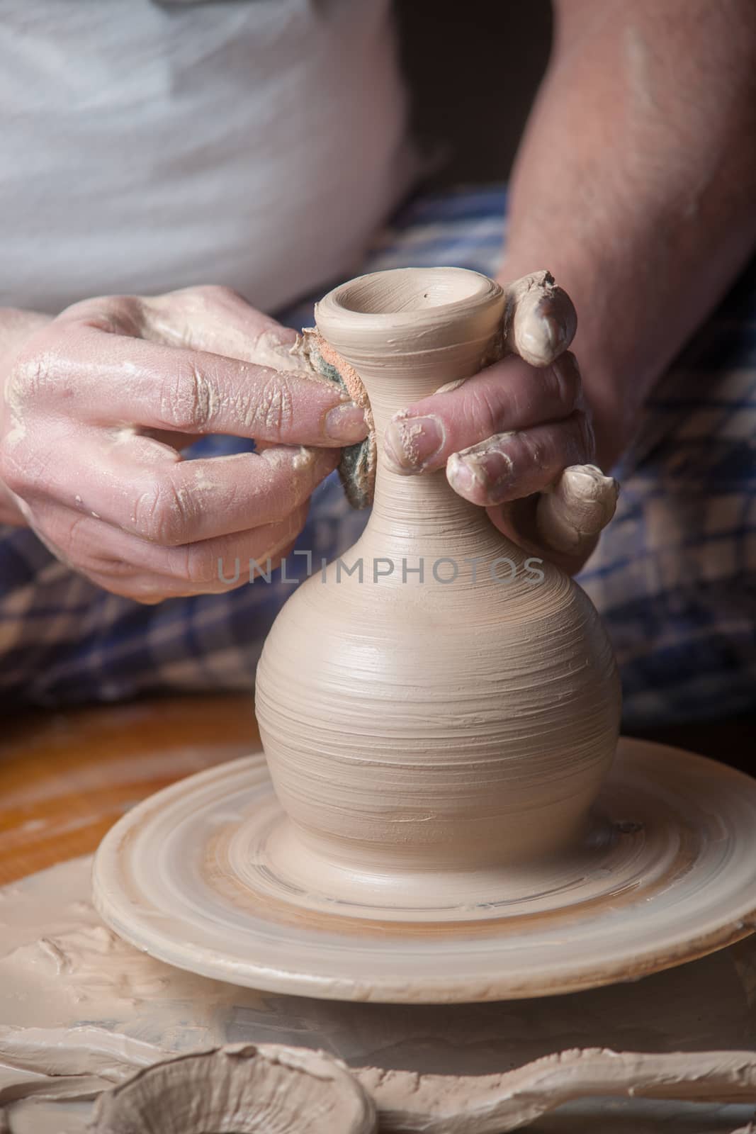 Hands of a potter, creating an earthen jar on the circle