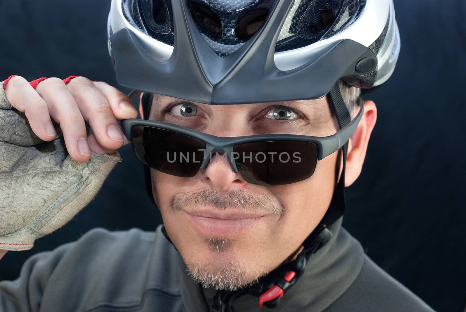 Close-up of friendly bicycle courierlooks over his sunglasses.