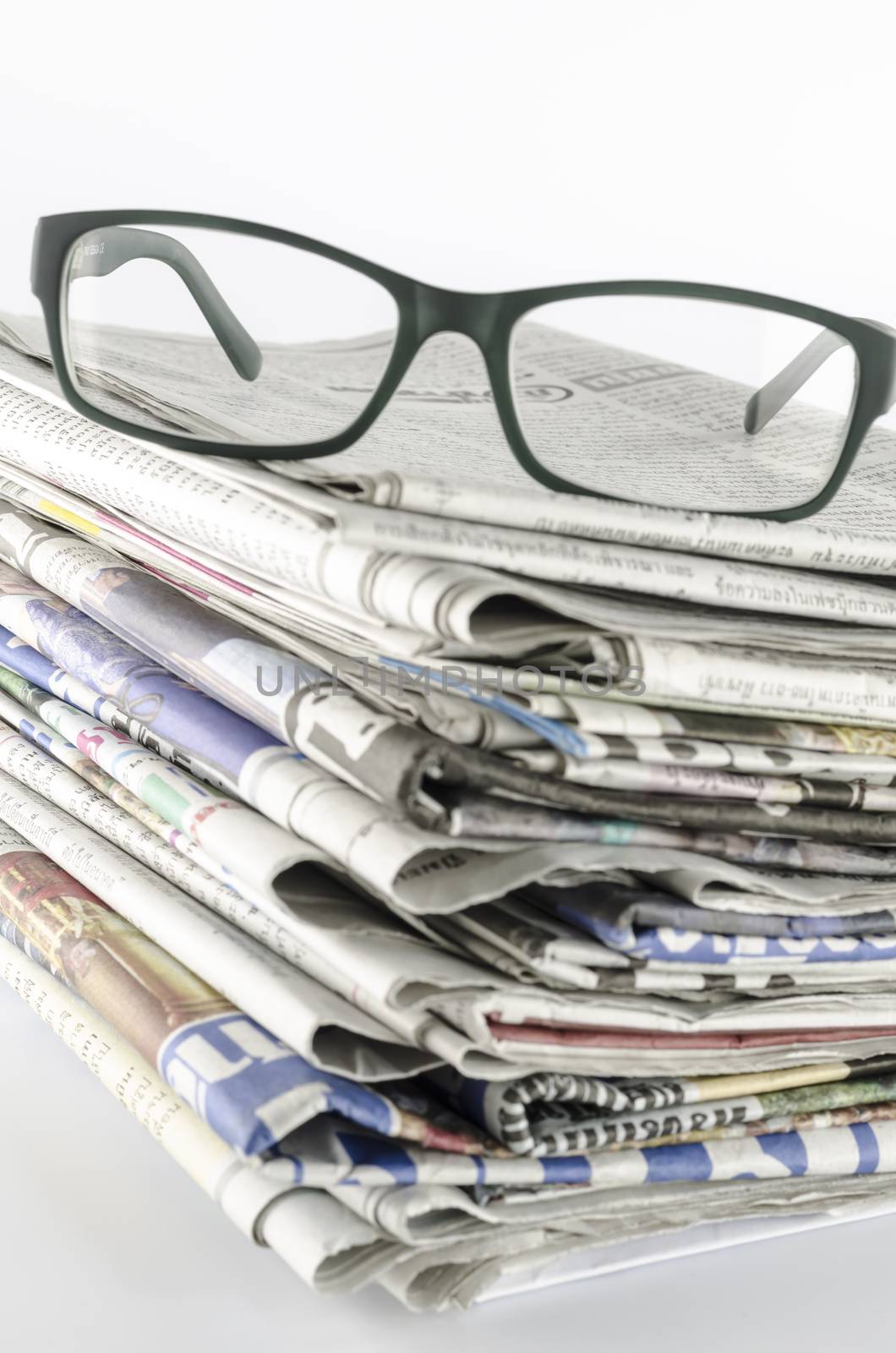 stack of newspaper with glasses by ammza12