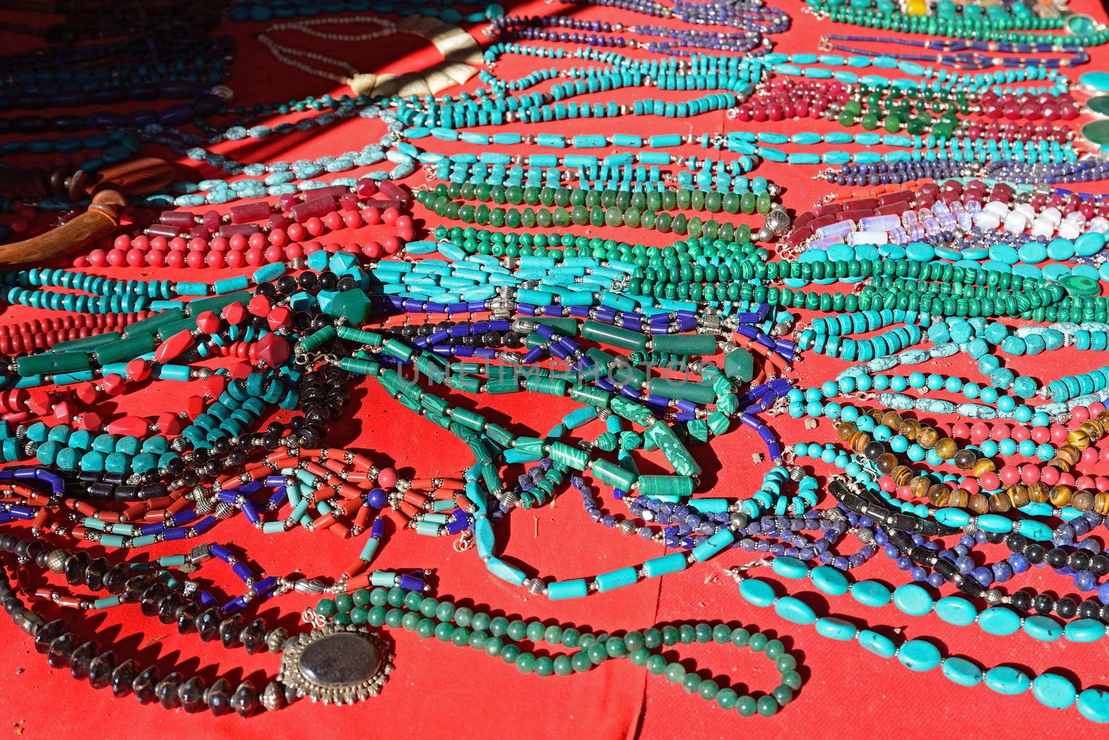 Various colorful Necklaces on red background at flea market in India