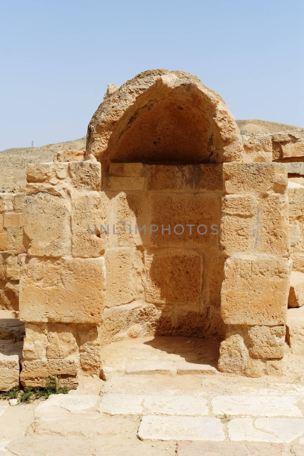 Ancient stone wall with arched niche in Mamshit excavations in Israel