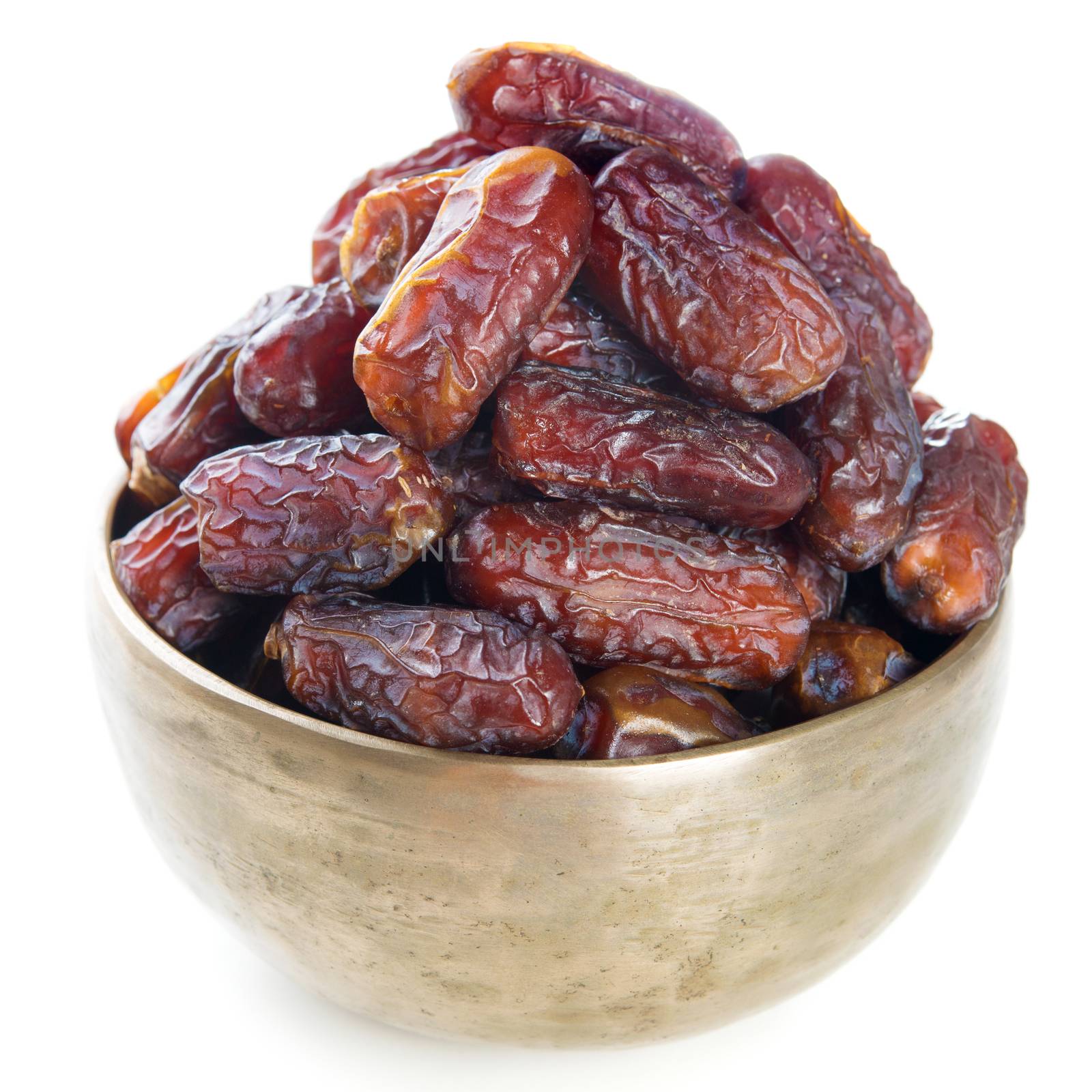 Dried date palm fruits or kurma, ramadan food which eaten in fasting month. Pile of fresh dried date fruits in golden metal bowl isolated on white background.