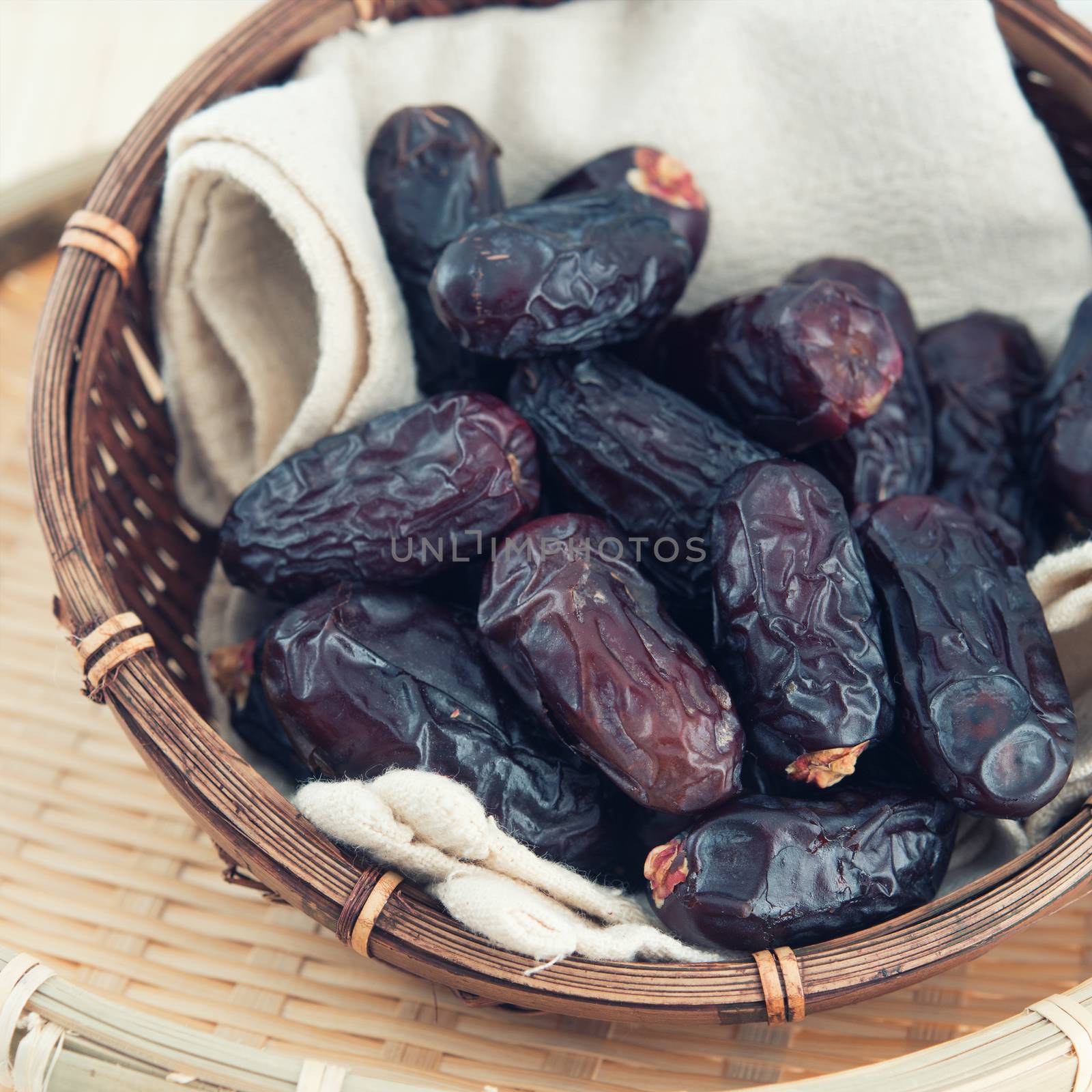 Dates fruit or kurma. Pile of fresh dried date fruits in a basket.