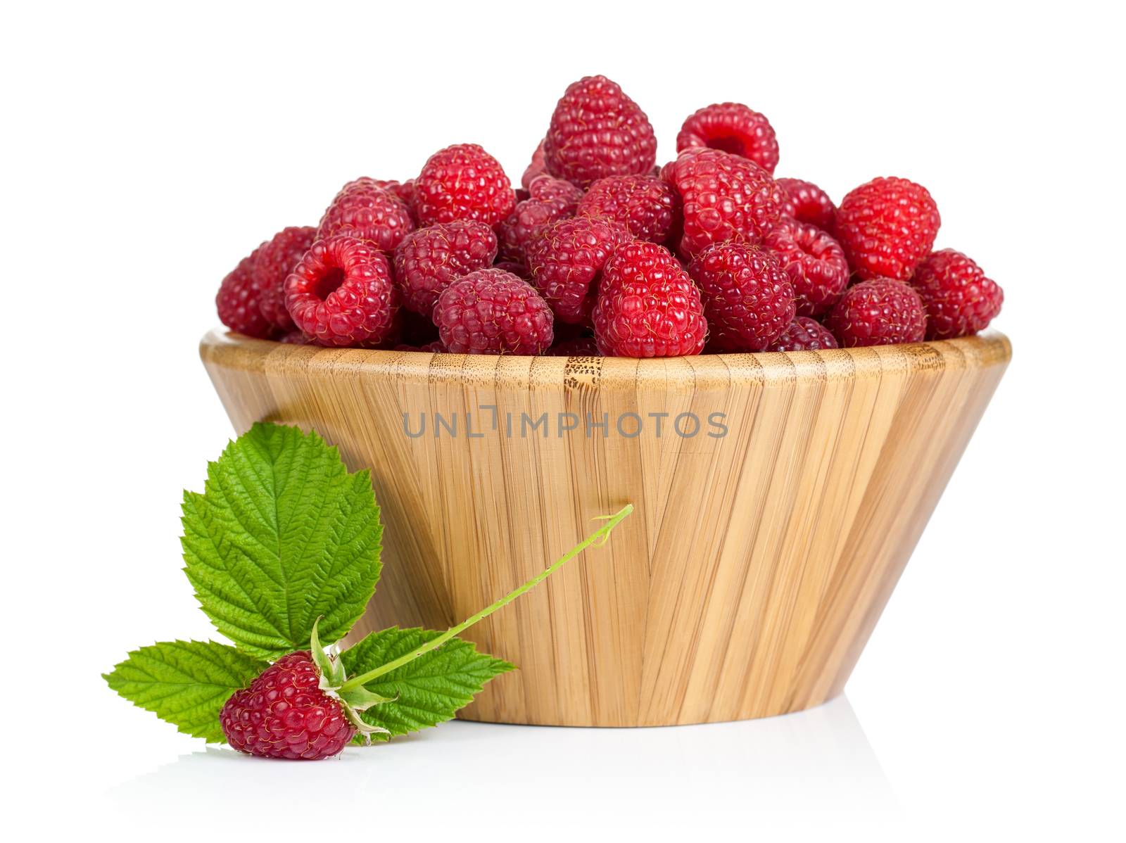 Fresh raspberries in wooden bowl on white background