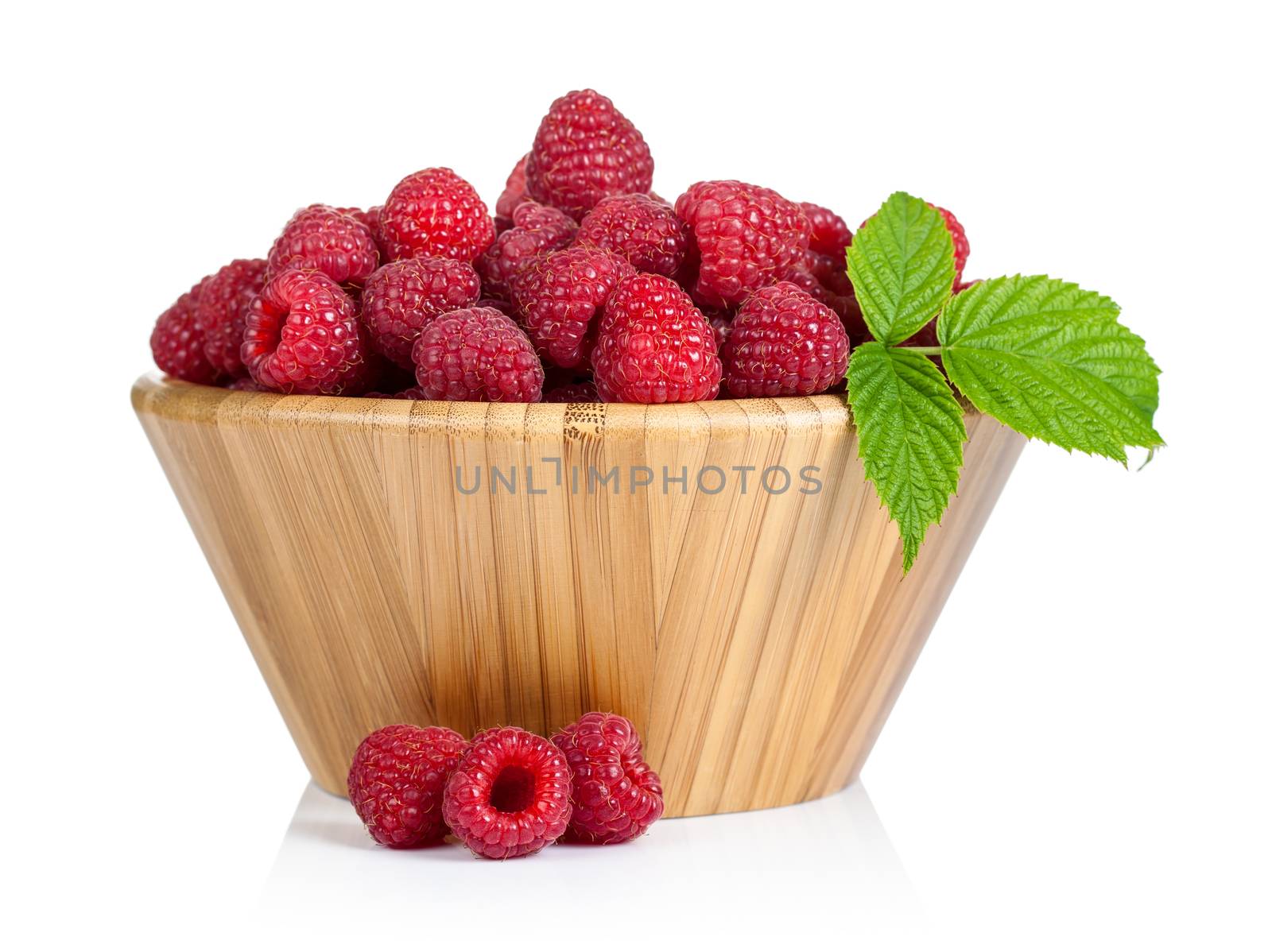 Fresh raspberries in wooden bowl on white background