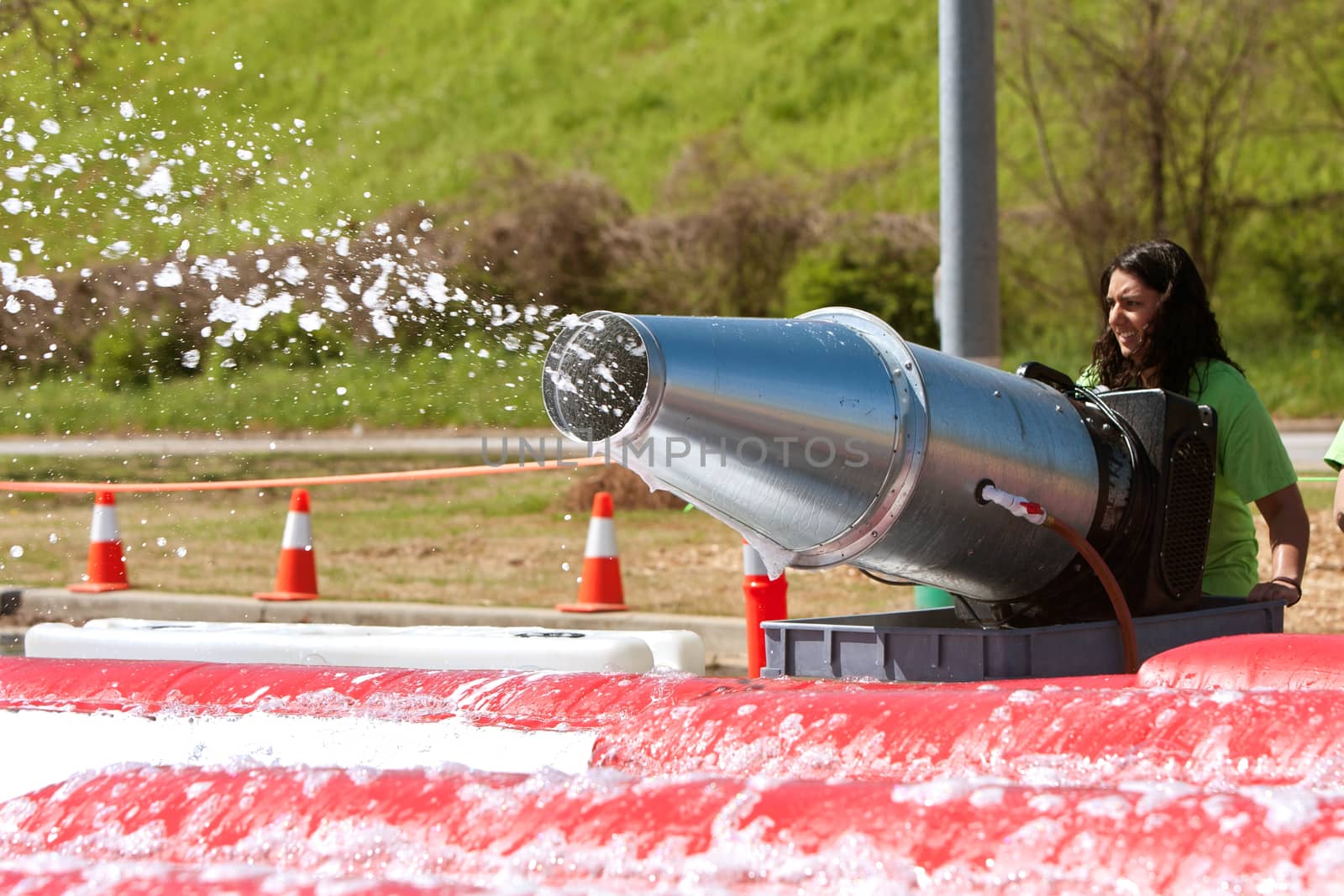 Atlanta, GA USA - April 5, 2014:  A young woman operates a large bubble machine to fill the foam pit with soap suds, at the Ridiculous Obstacle Challenge (ROC) 5K race.