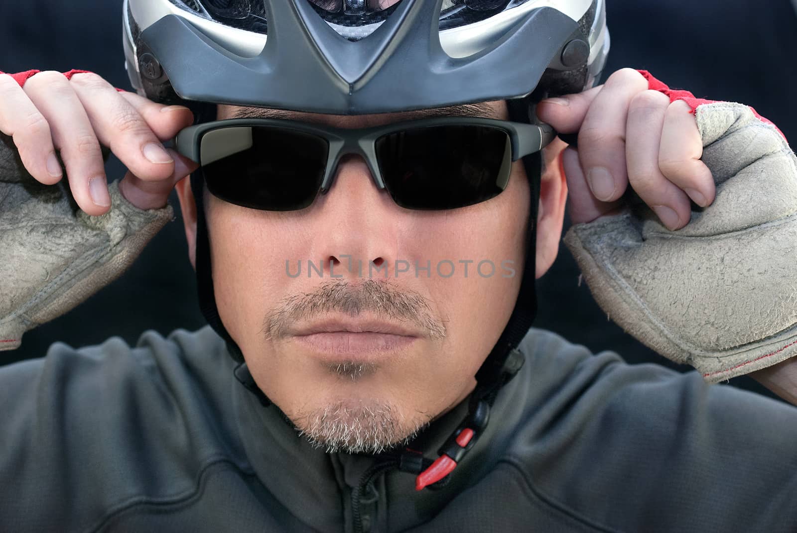 Close-up of bicycle courier putting on his sunglasses.