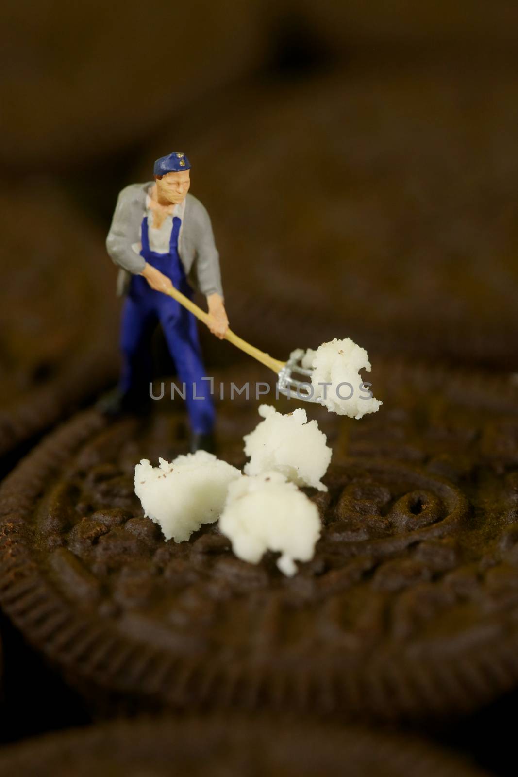 Miniature Plastic People Cleaning Up a Messy Cookie