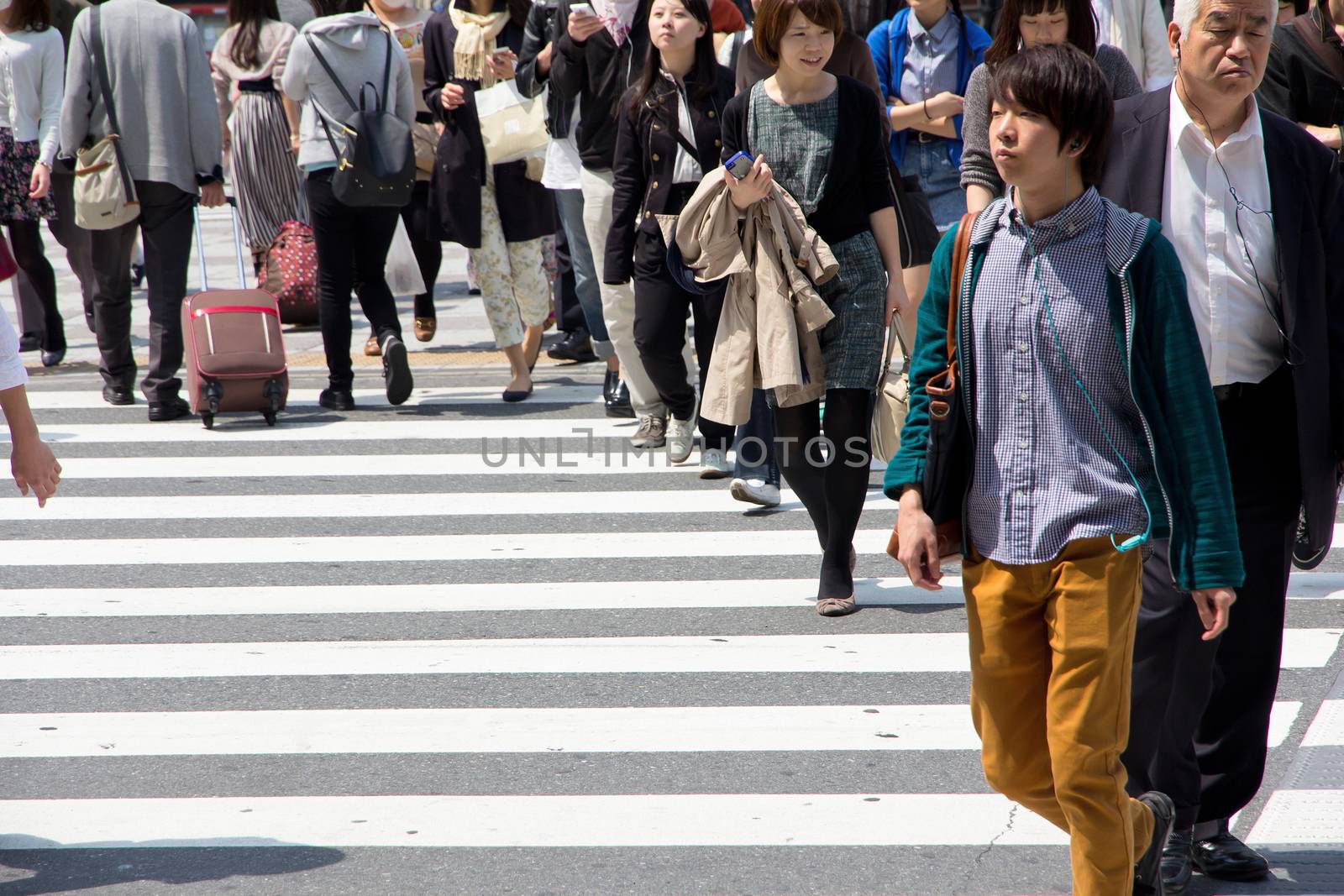 Tokyo, Japan - April 15, 2014 Crowds of pedestrians crossing the busy downtown streets of Shibuya, the most important commercial center in Tokyo, Japan