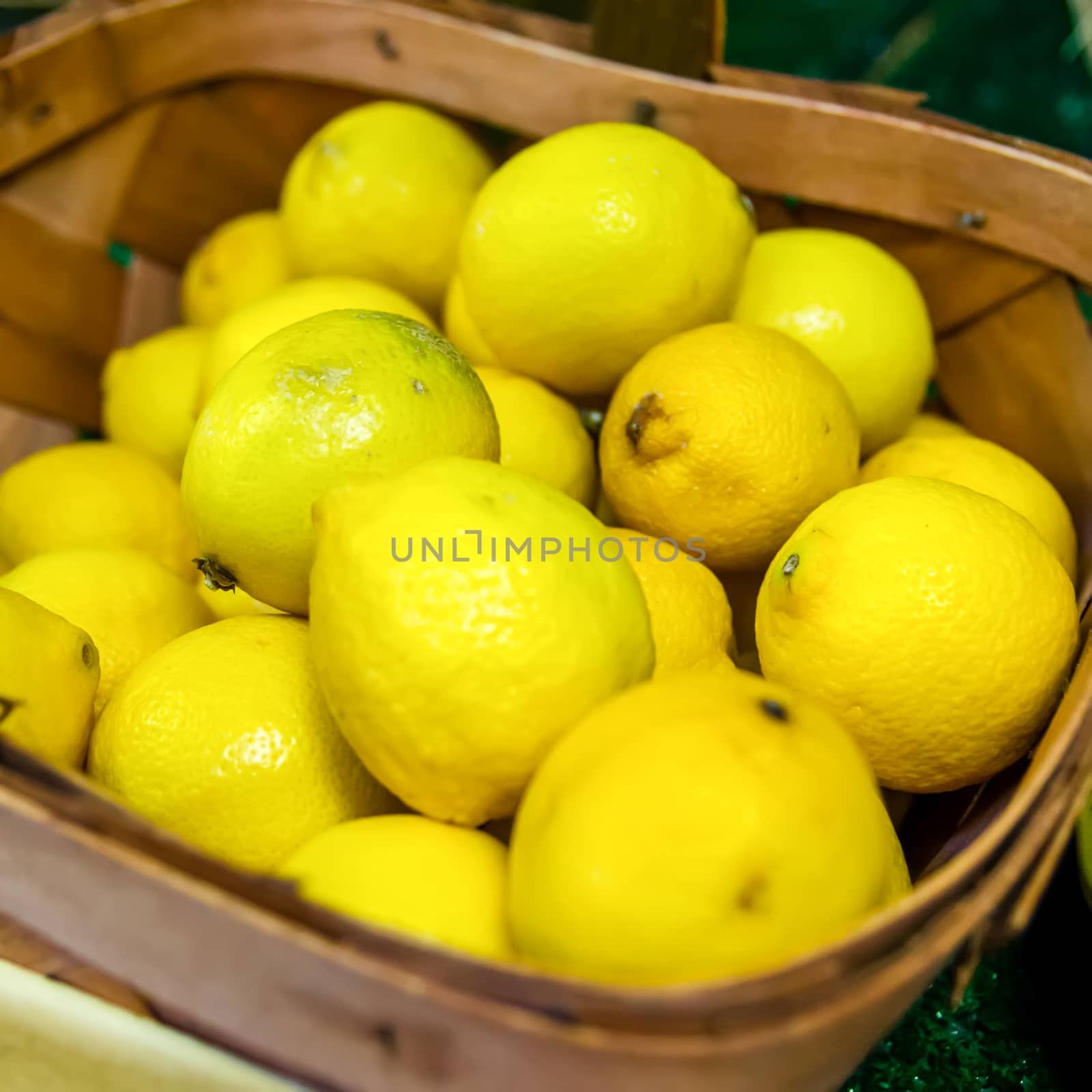 Colorful Display Of Lemons In Market in a basket by digidreamgrafix