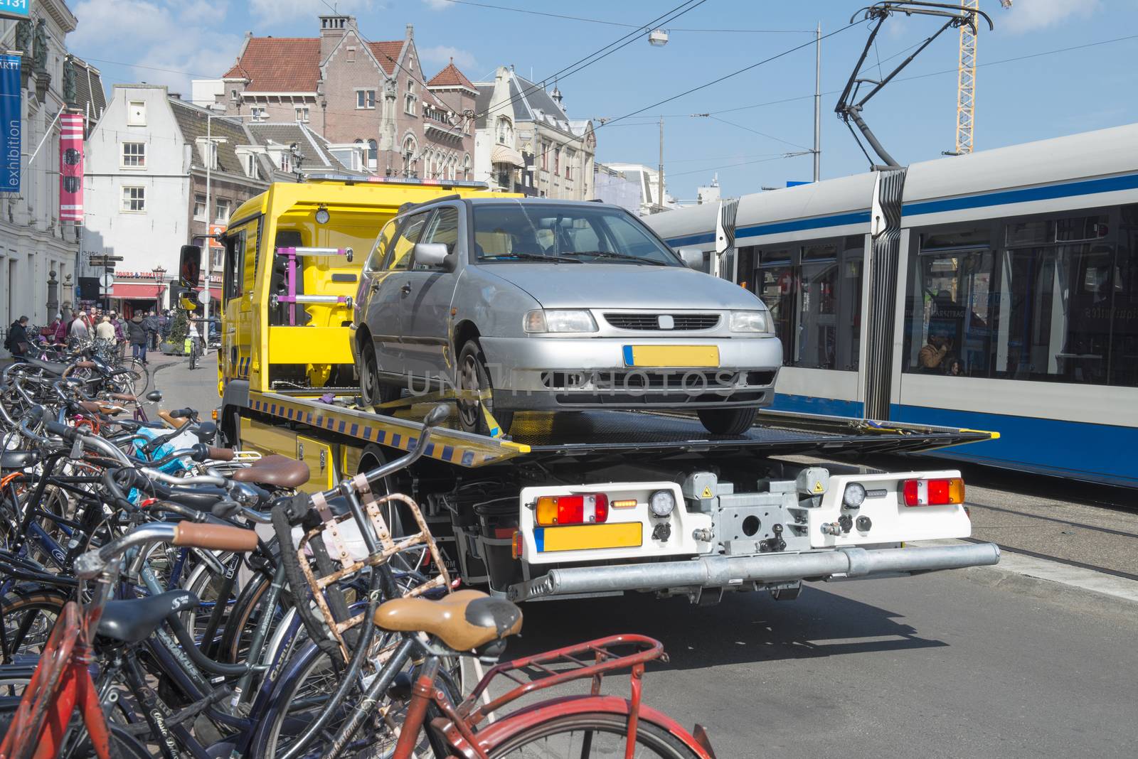 Amsterdam, The Netherlands - April 05, 2014; Tow Truck urban towing away a wrongly parked car in Amsterdam.
