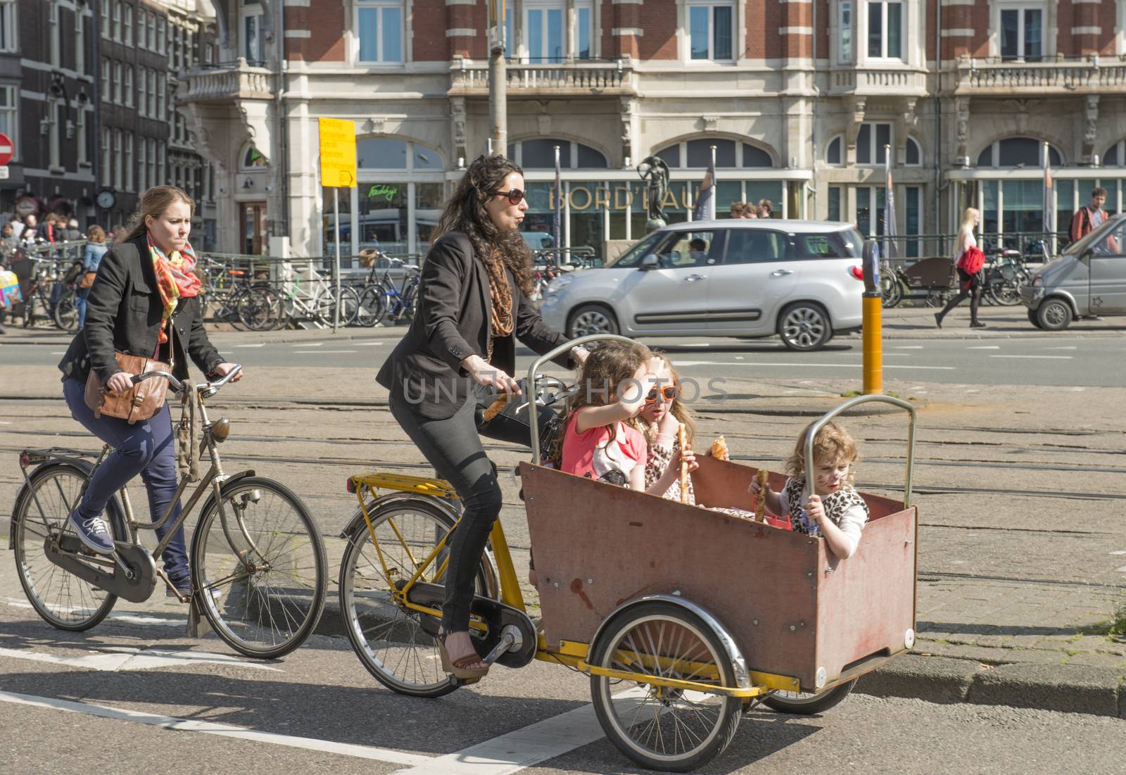 Amsterdam, The Netherlands - April 05, 2014; The half of all traffic movements in Amsterdam are by bike. The Dutch are proud of their biking culture through the city streets. Especially here are popular the baby bicycle carriages