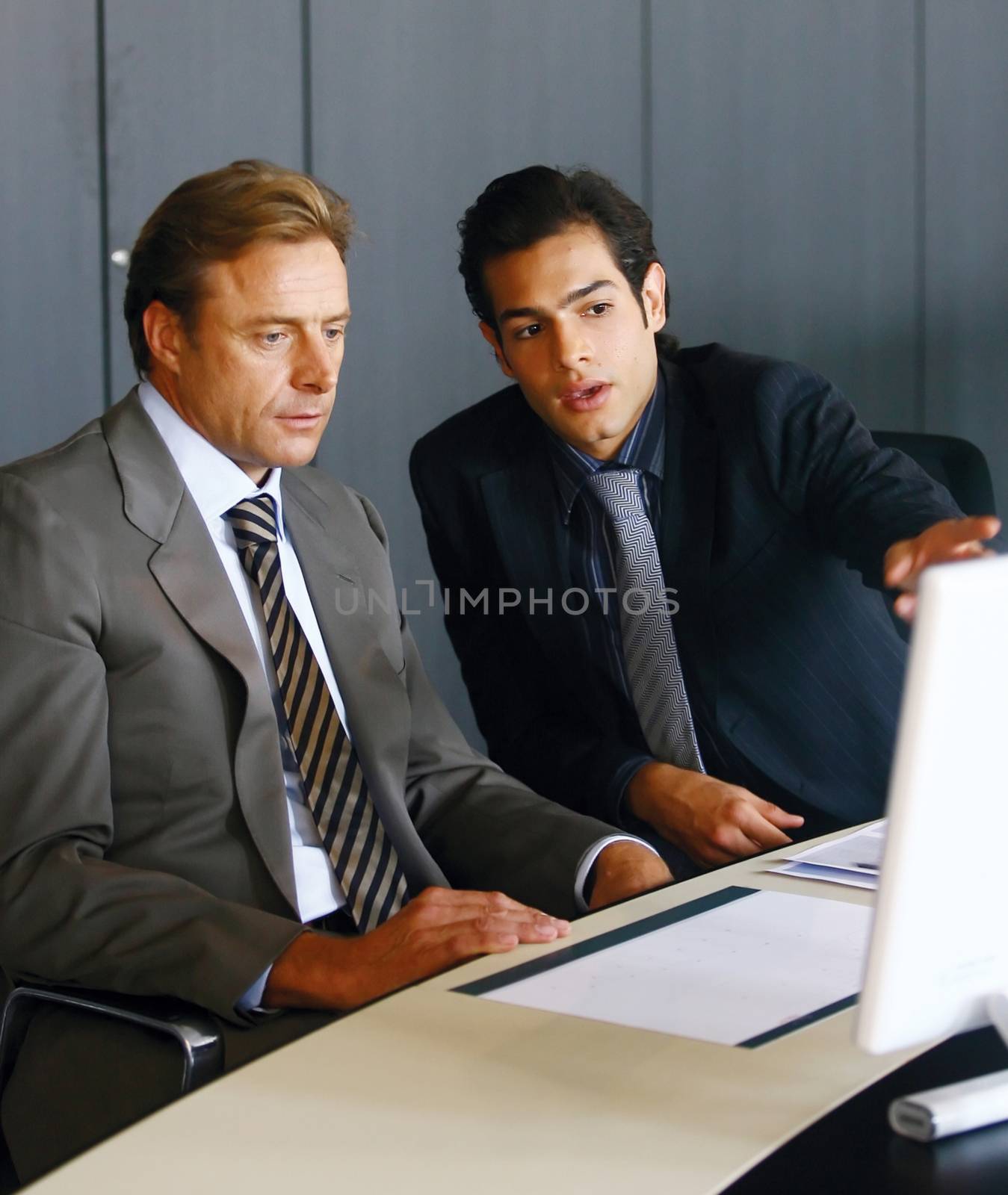 Two concentrated businessmen working together on a laptop in the office 