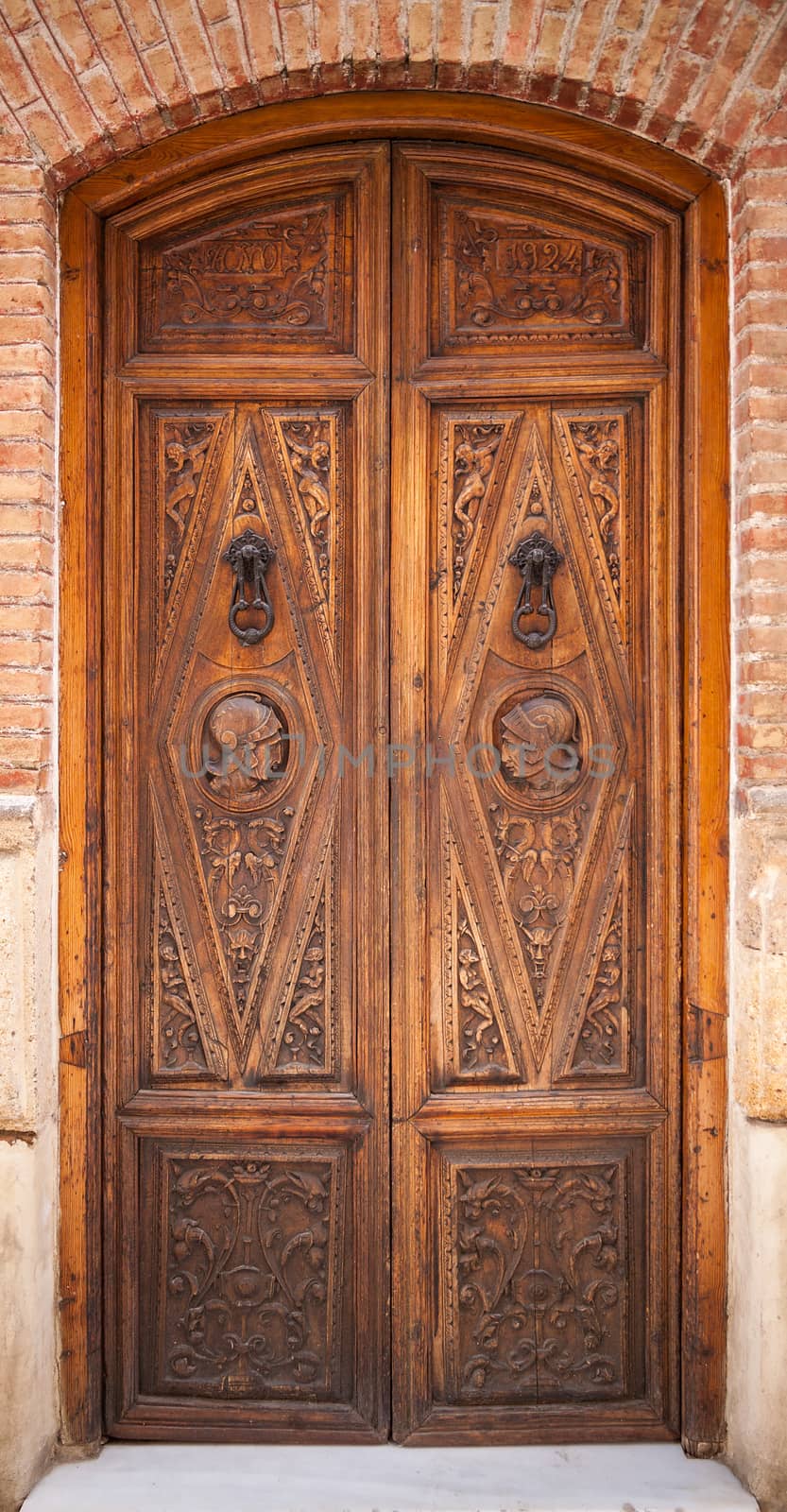 Decorated old wooden door with metal handles
