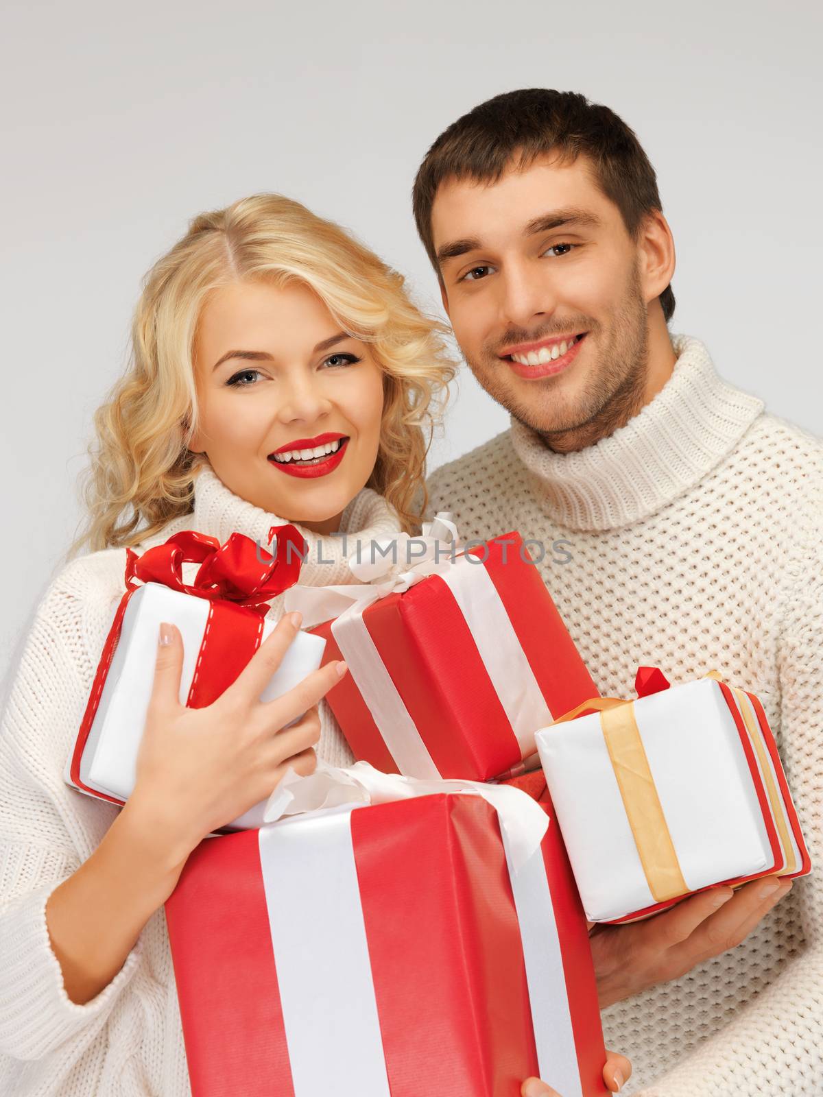 family couple in a sweaters with gift boxes by dolgachov