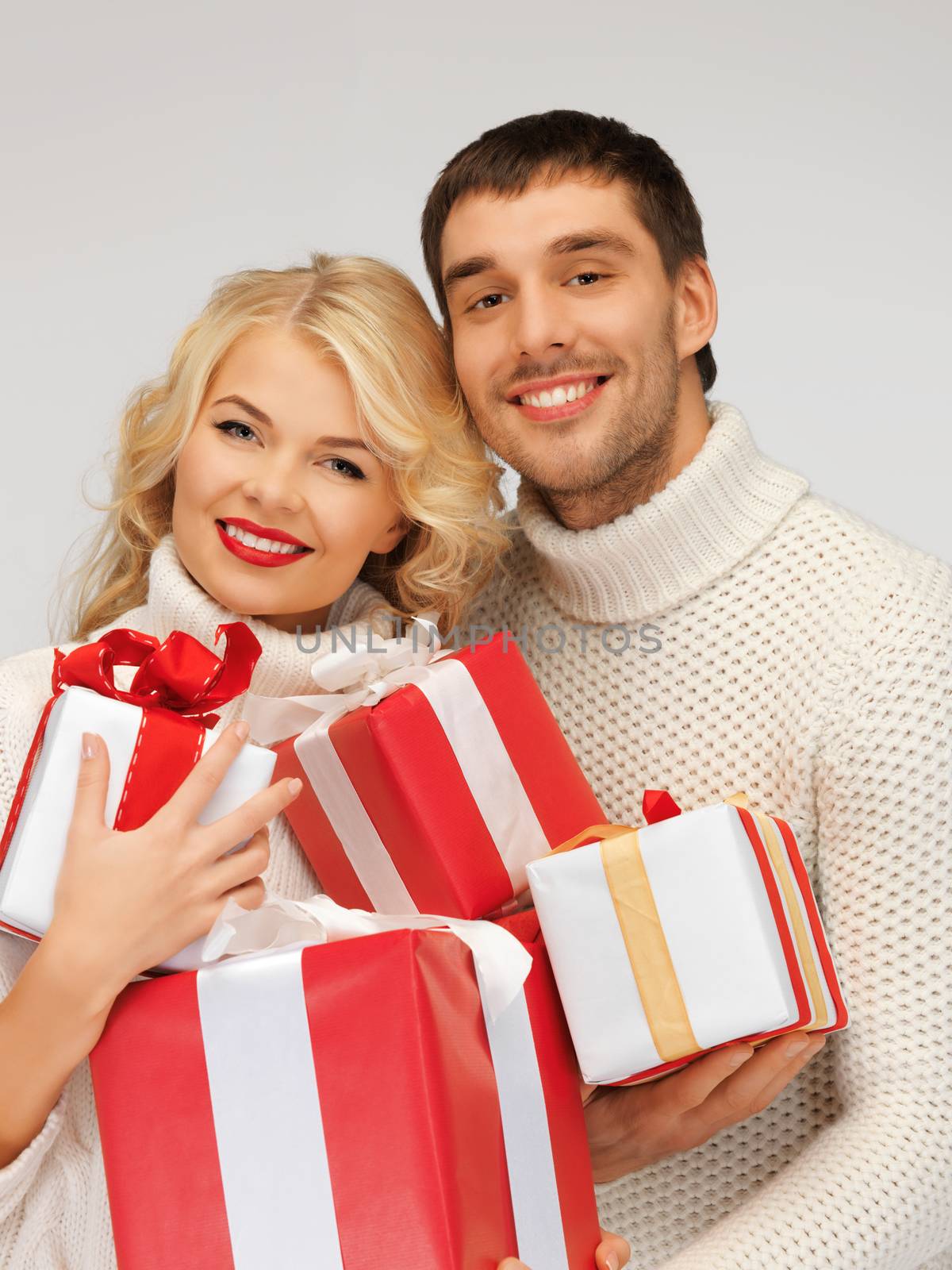 picture of family couple in a sweaters with gift boxes