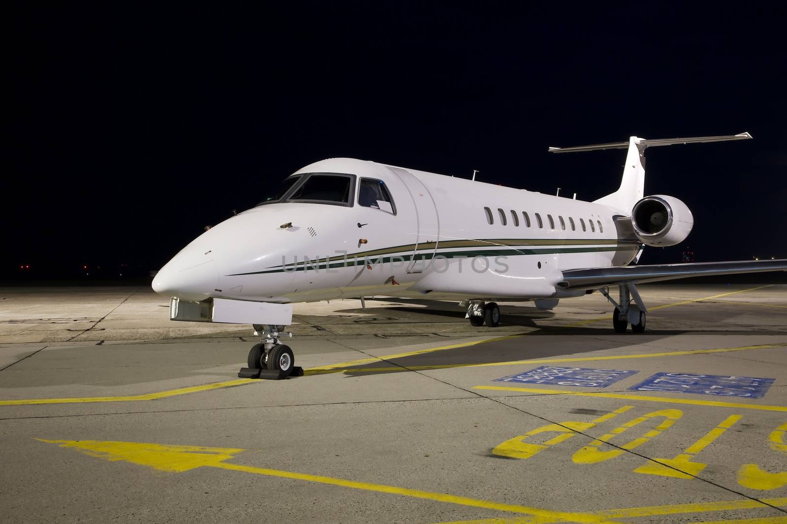 Small jet plane parked at night