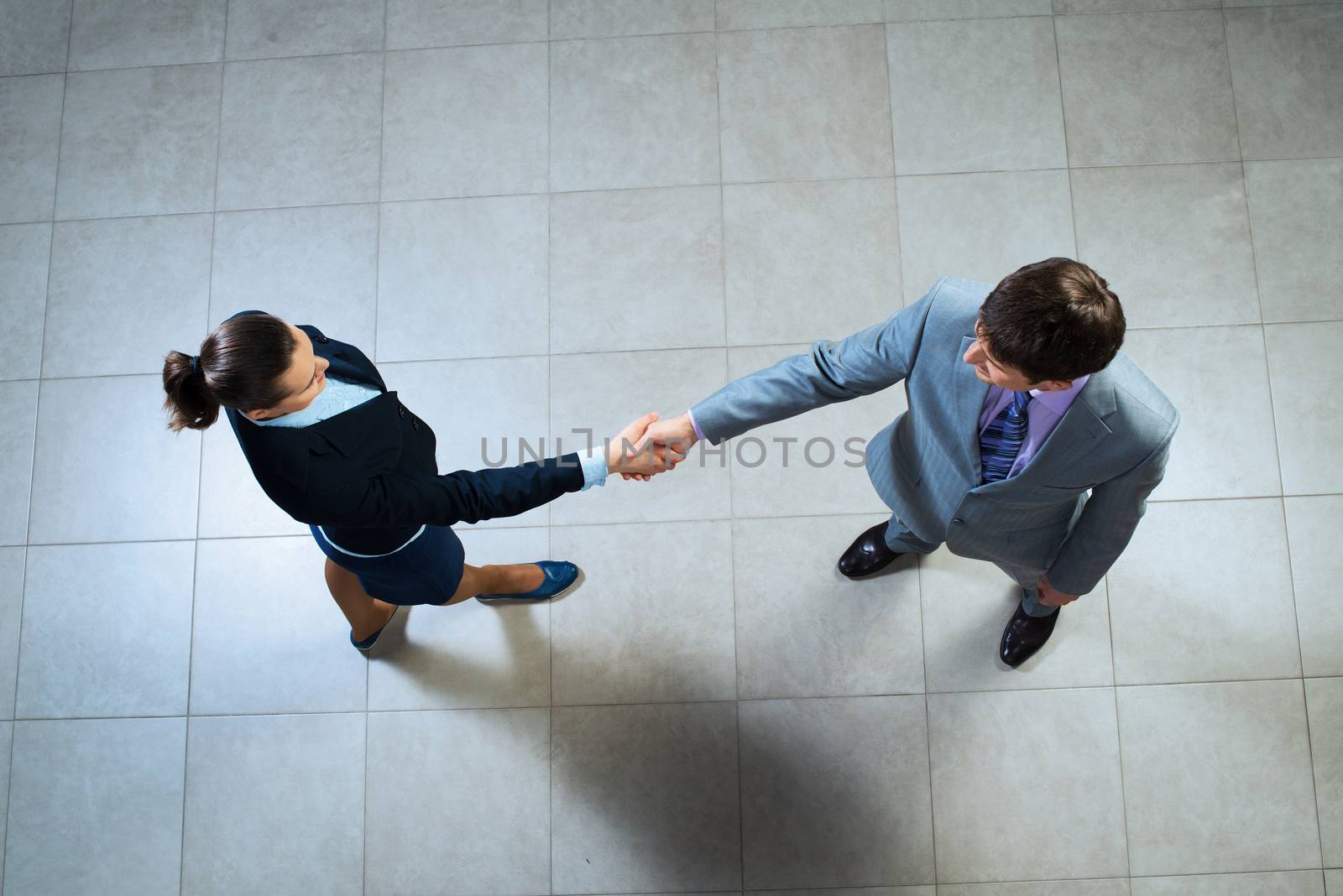 Business woman and businessman shaking hands by adam121