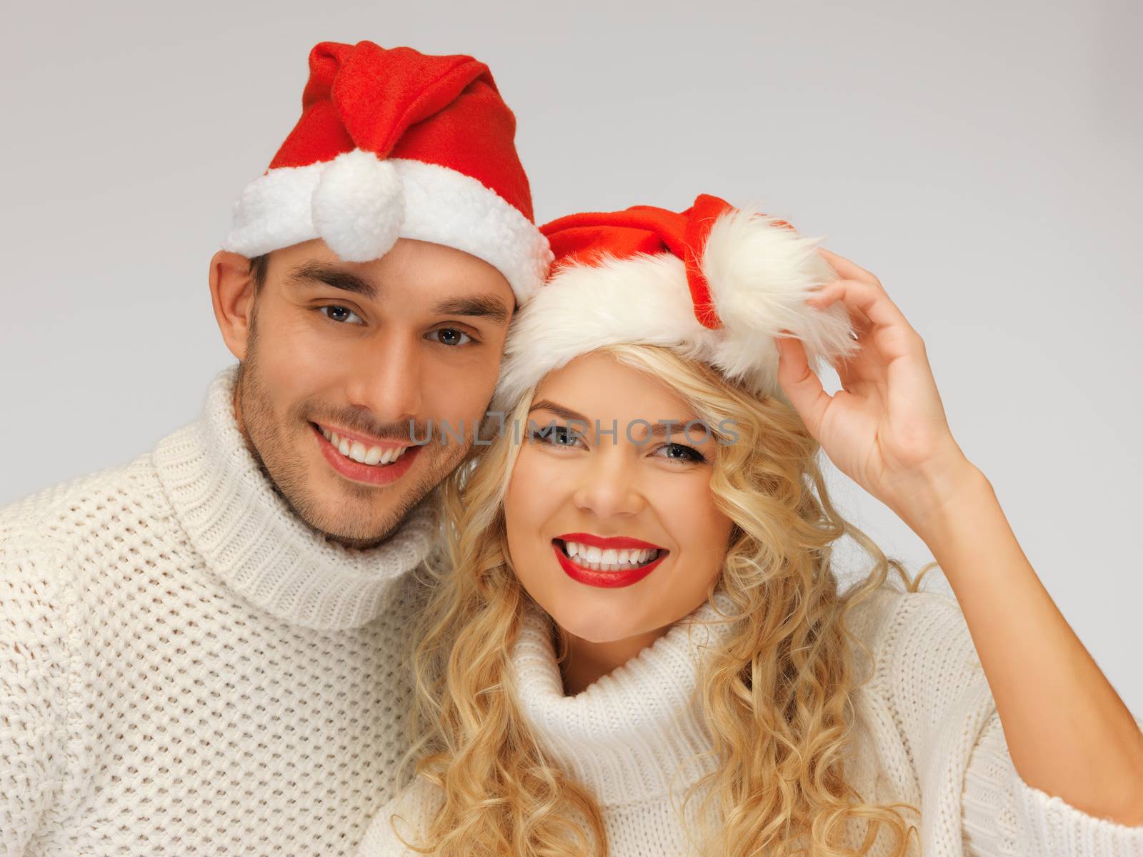 family couple in sweaters and santa's hats by dolgachov