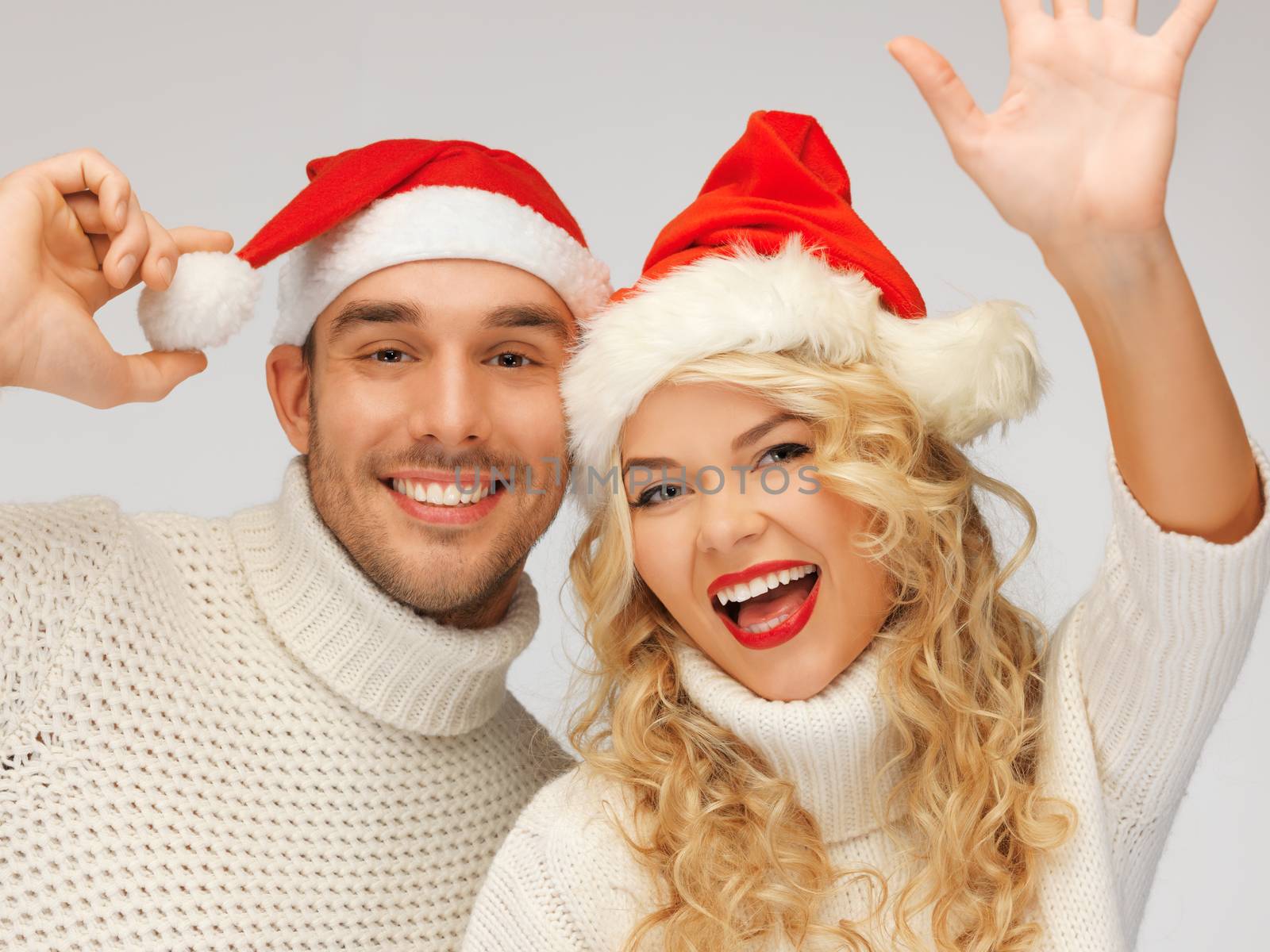 family couple in sweaters and santa's hats by dolgachov