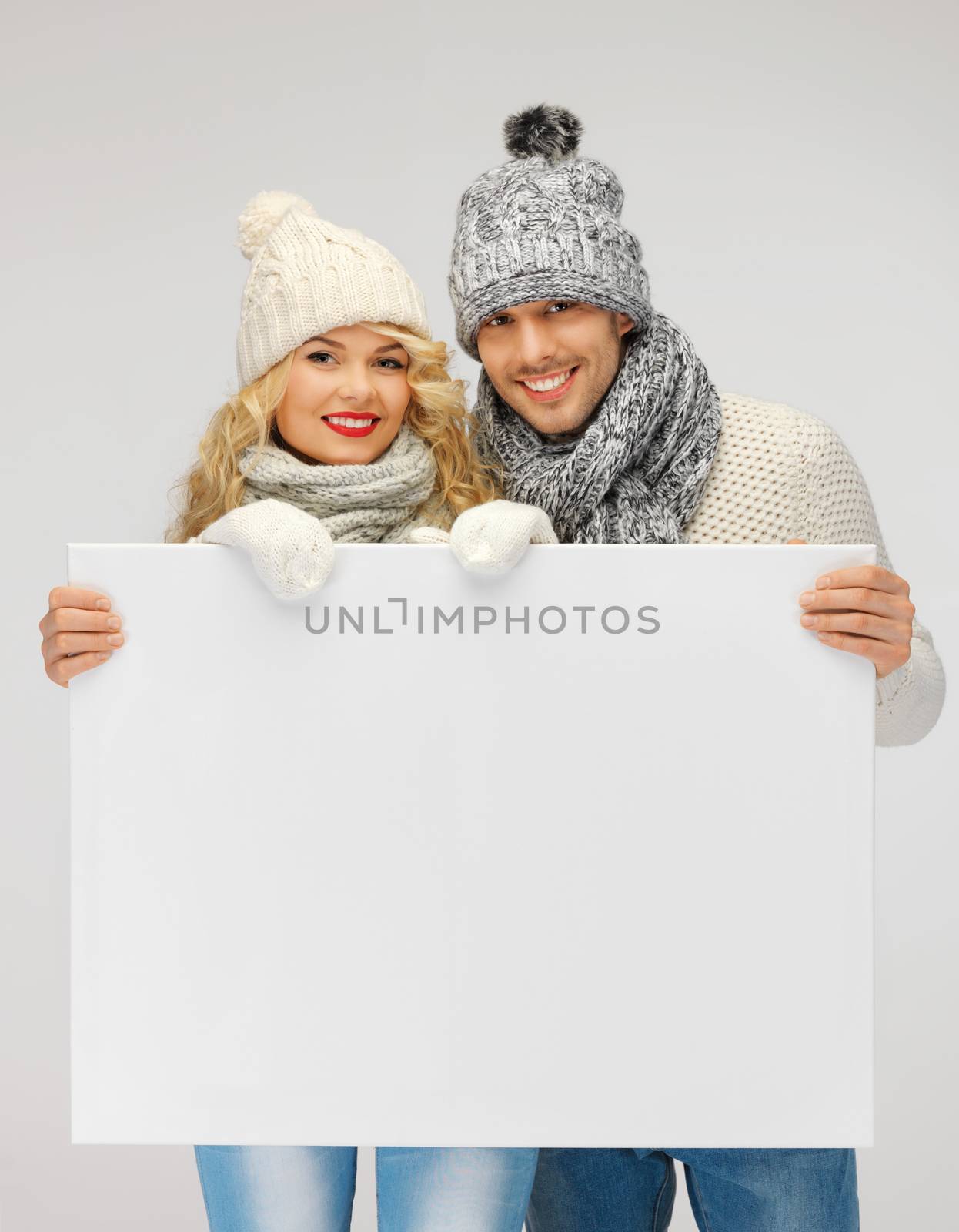 picture of family couple in a winter clothes holding blank board