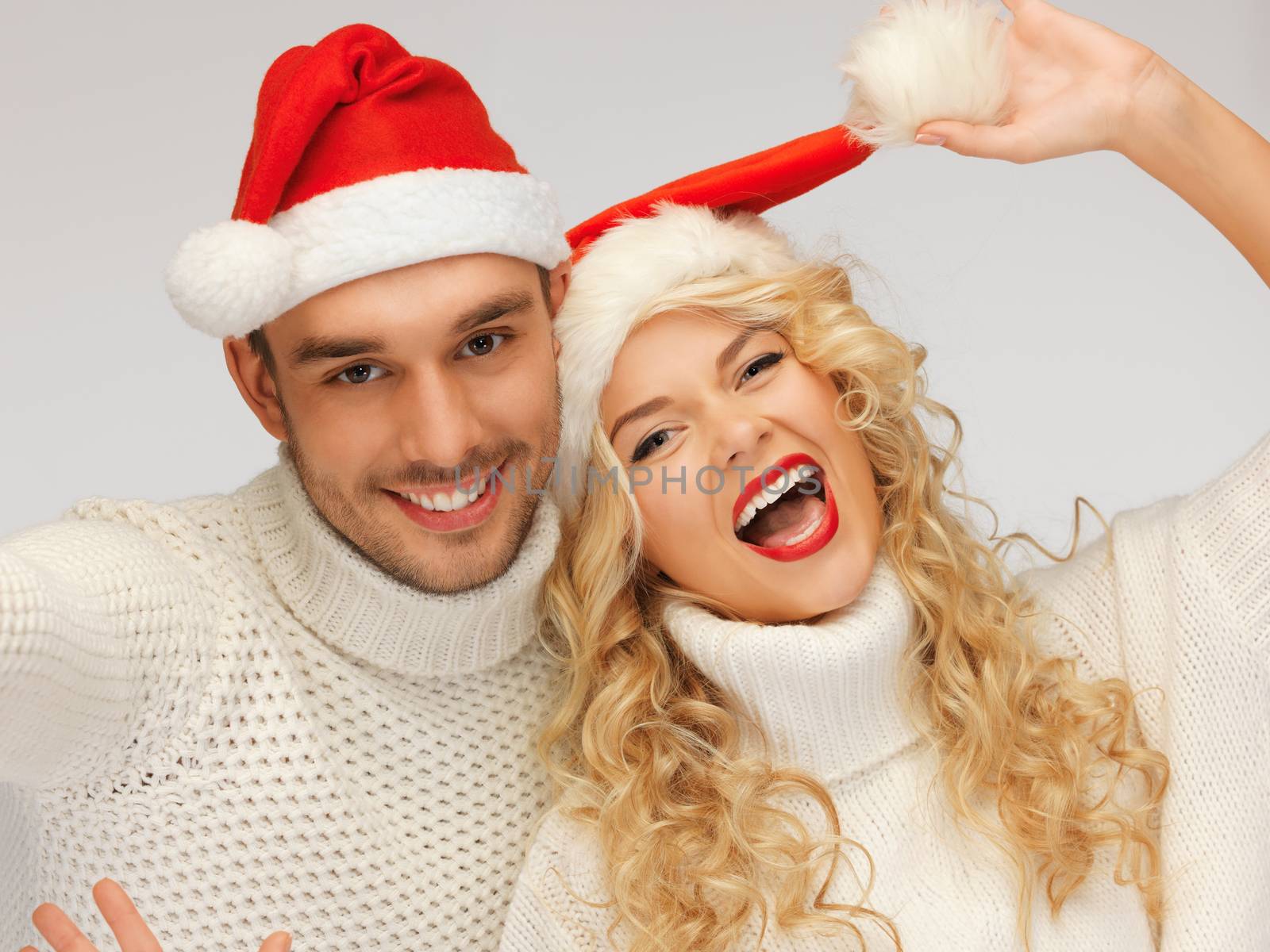 picture of family couple in sweaters and santa's hats