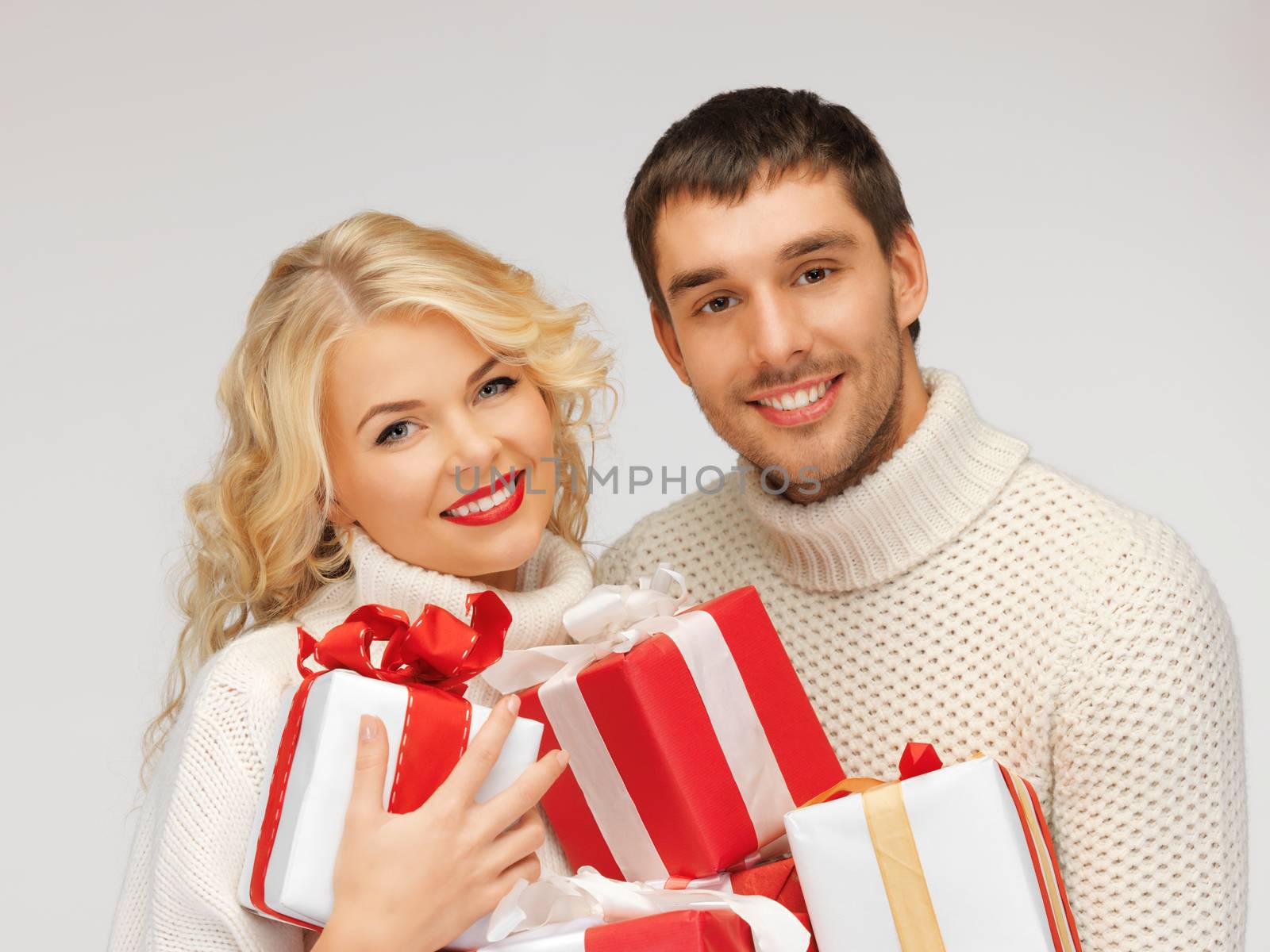 picture of family couple in a sweaters with gift boxes