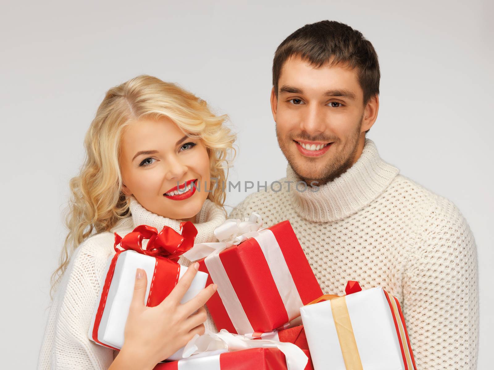 picture of family couple in a sweaters with gift boxes