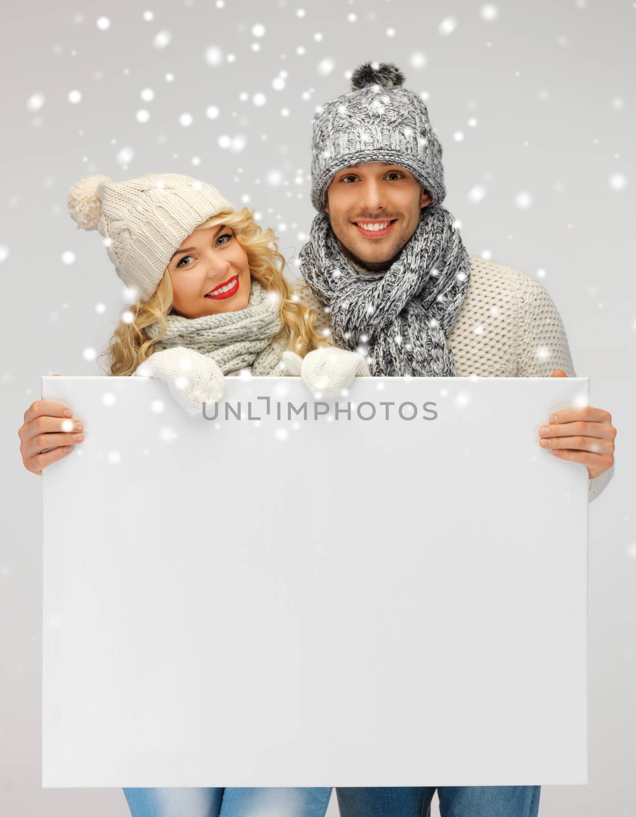 couple in a winter clothes holding blank board by dolgachov